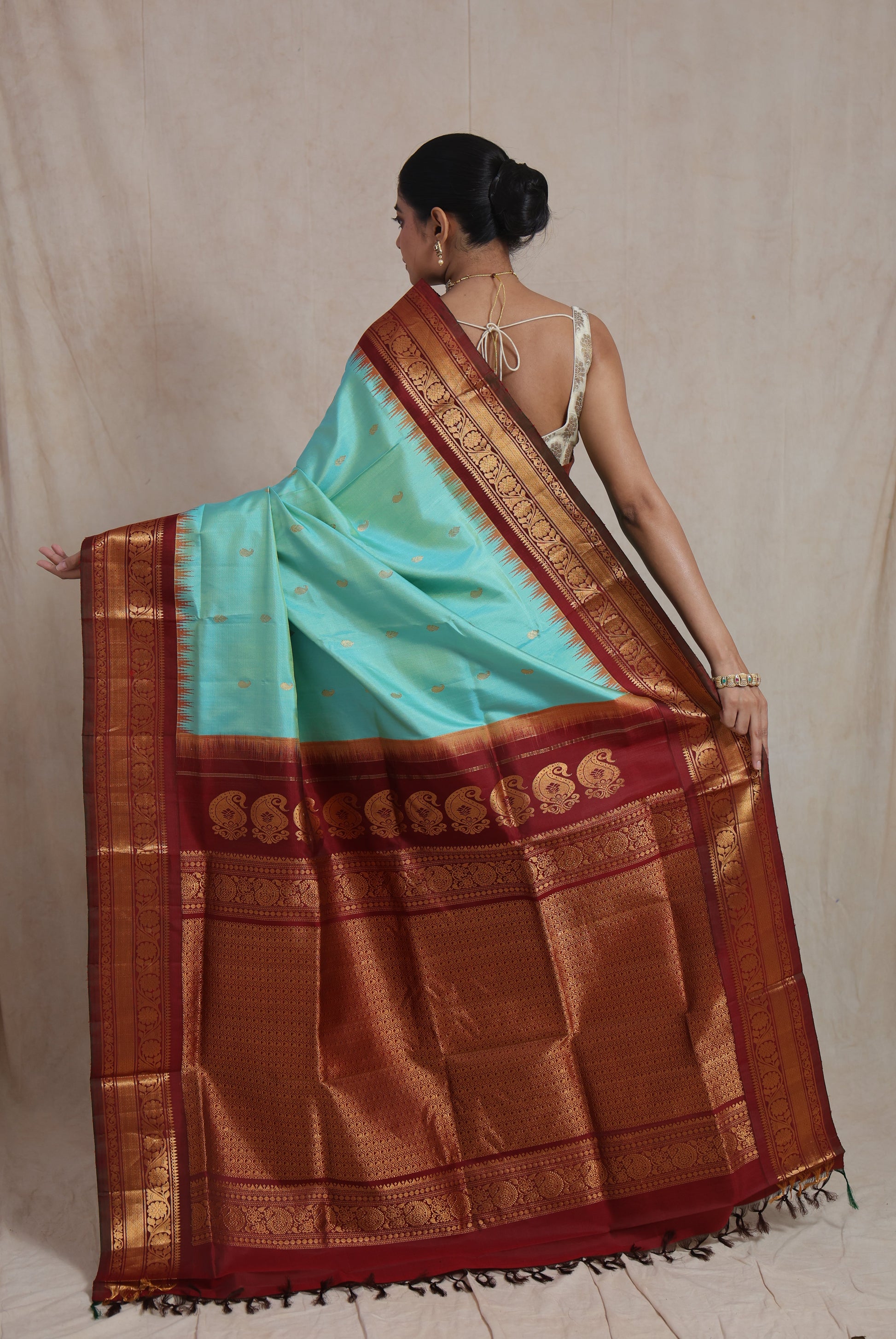 Portrait view of mint green Gadwal silk saree with maroon zari border