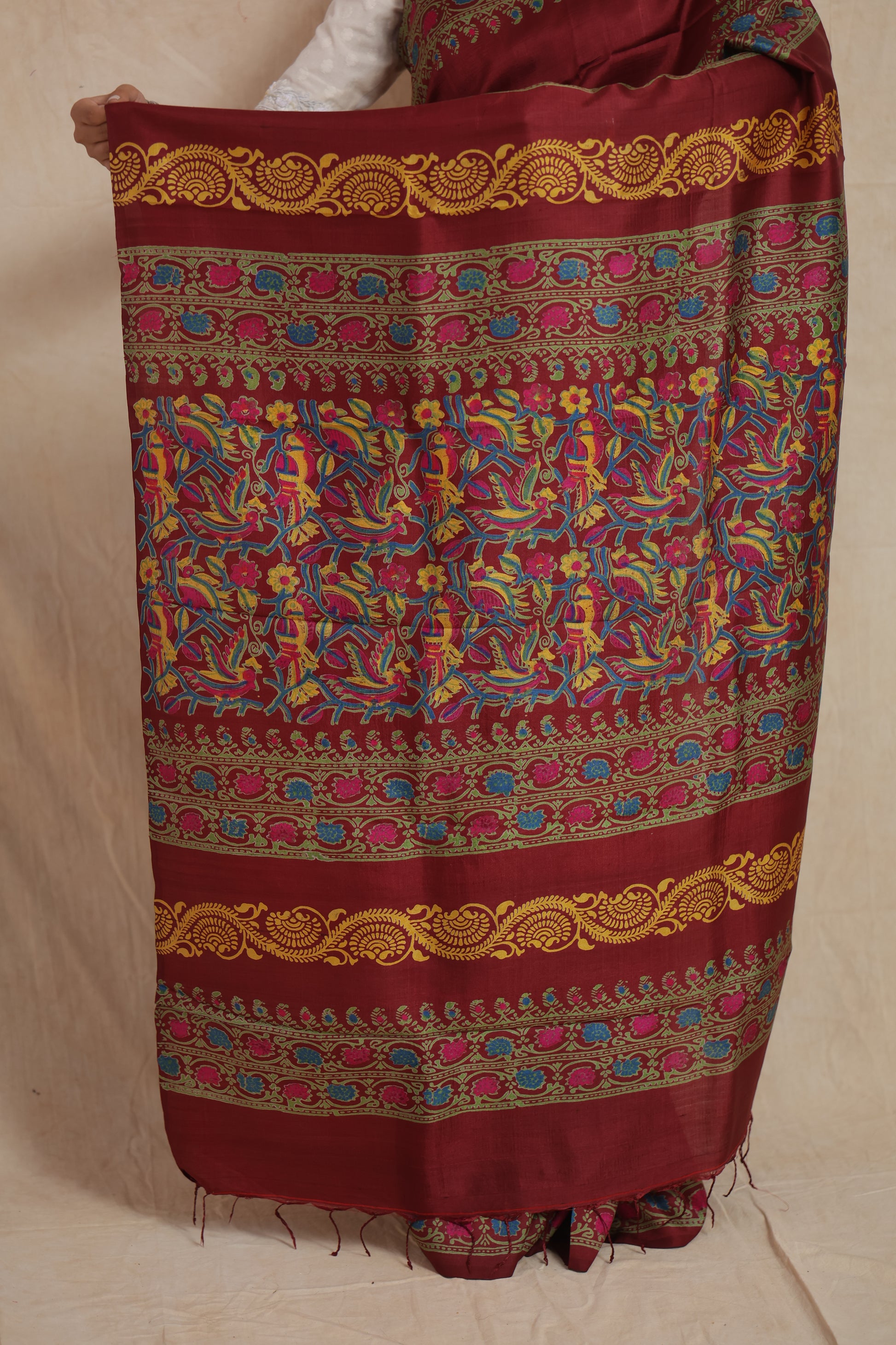 Detailed pallu design of deep maroon Batik silk saree with vibrant traditional motifs