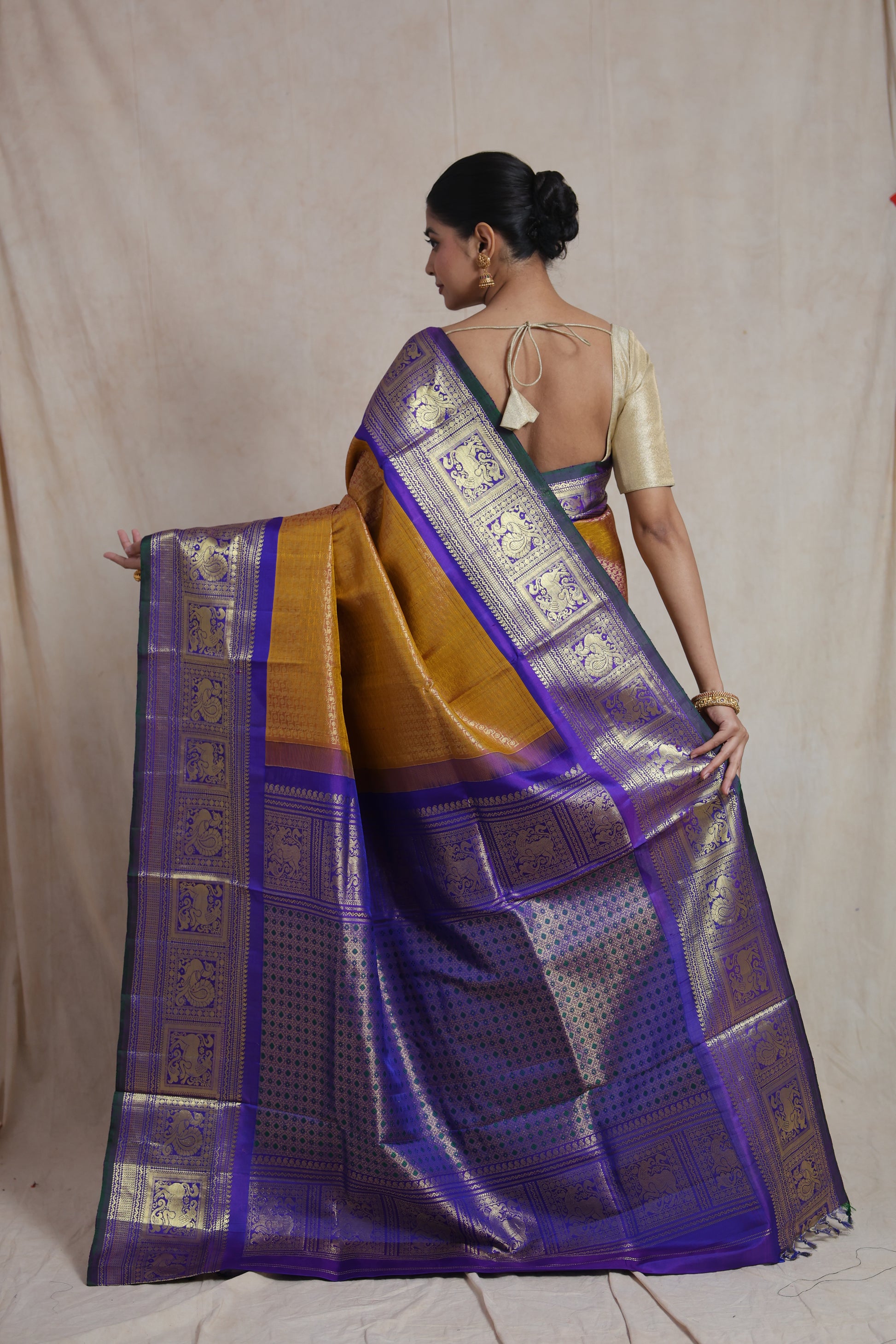 Back pallu view of mustard gold Gadwal Silk saree with royal purple zari border