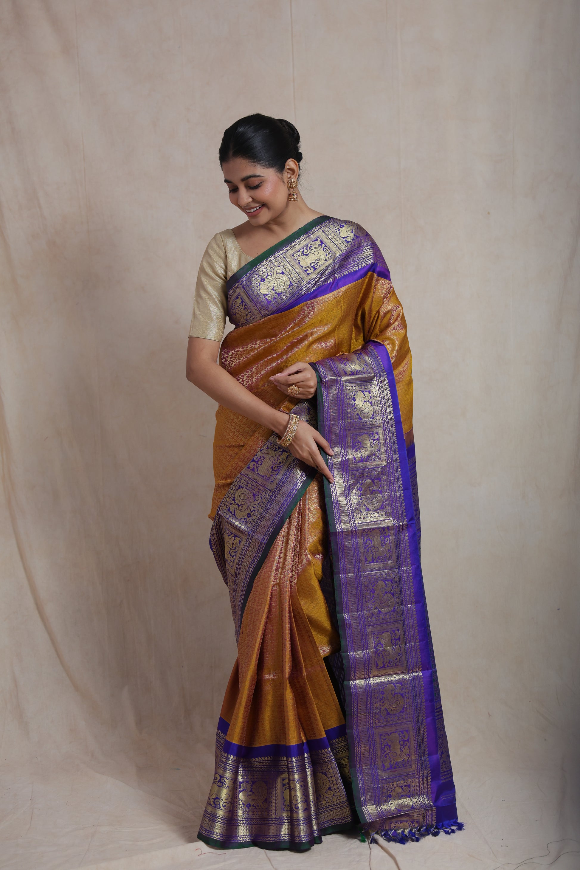 Graceful pose featuring mustard gold Gadwal Silk saree with rich woven border