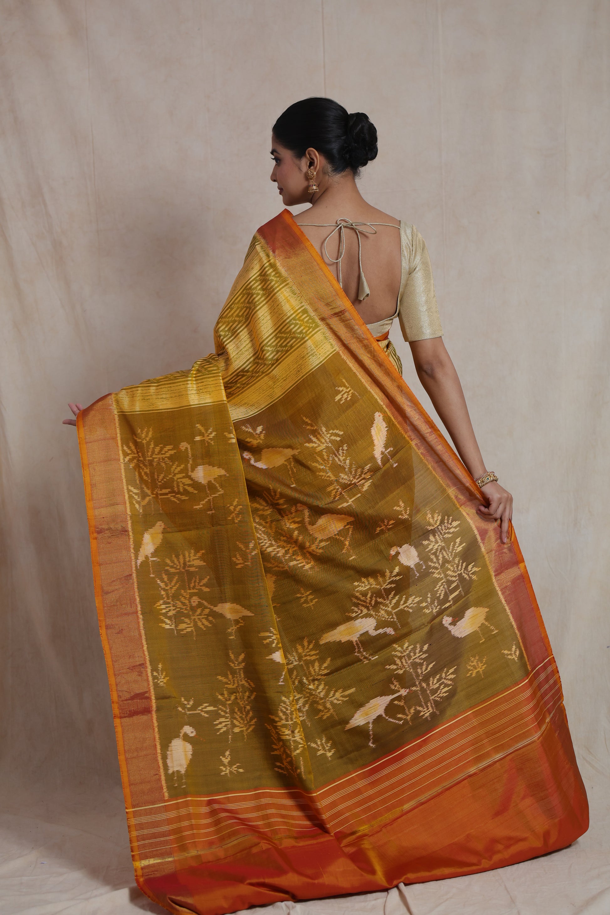 Back view of mustard yellow Patola silk saree with artistic woven pallu