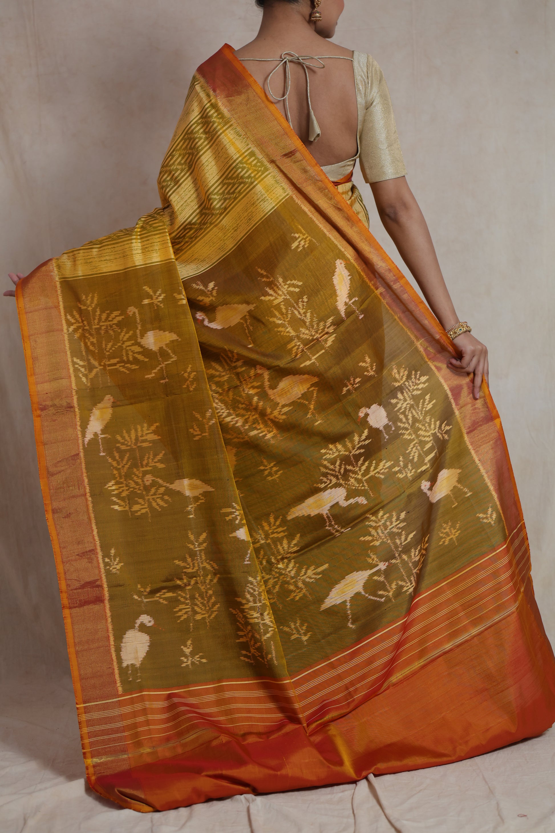 Close-up of woven bird motifs on mustard yellow Patola silk saree pallu