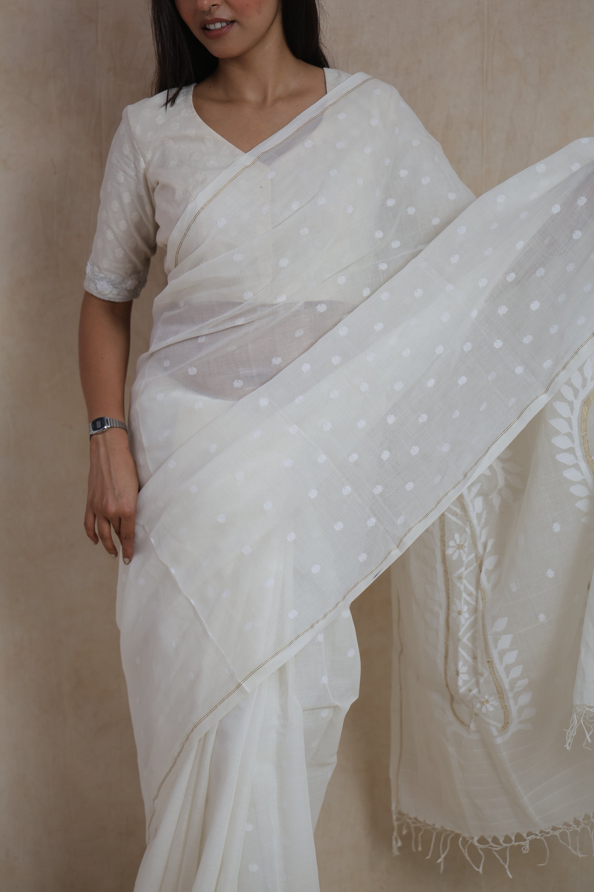 Close-up of off-white Bengal Fulia cotton saree showcasing fine butti motifs and soft handwoven texture