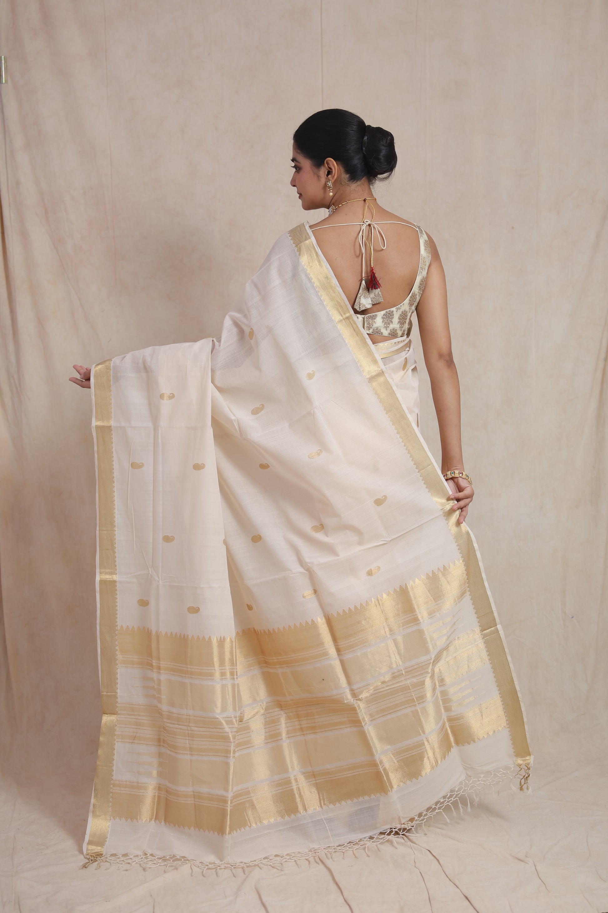 Back view of off white Kanchipuram cotton saree with golden woven border and striped pallu