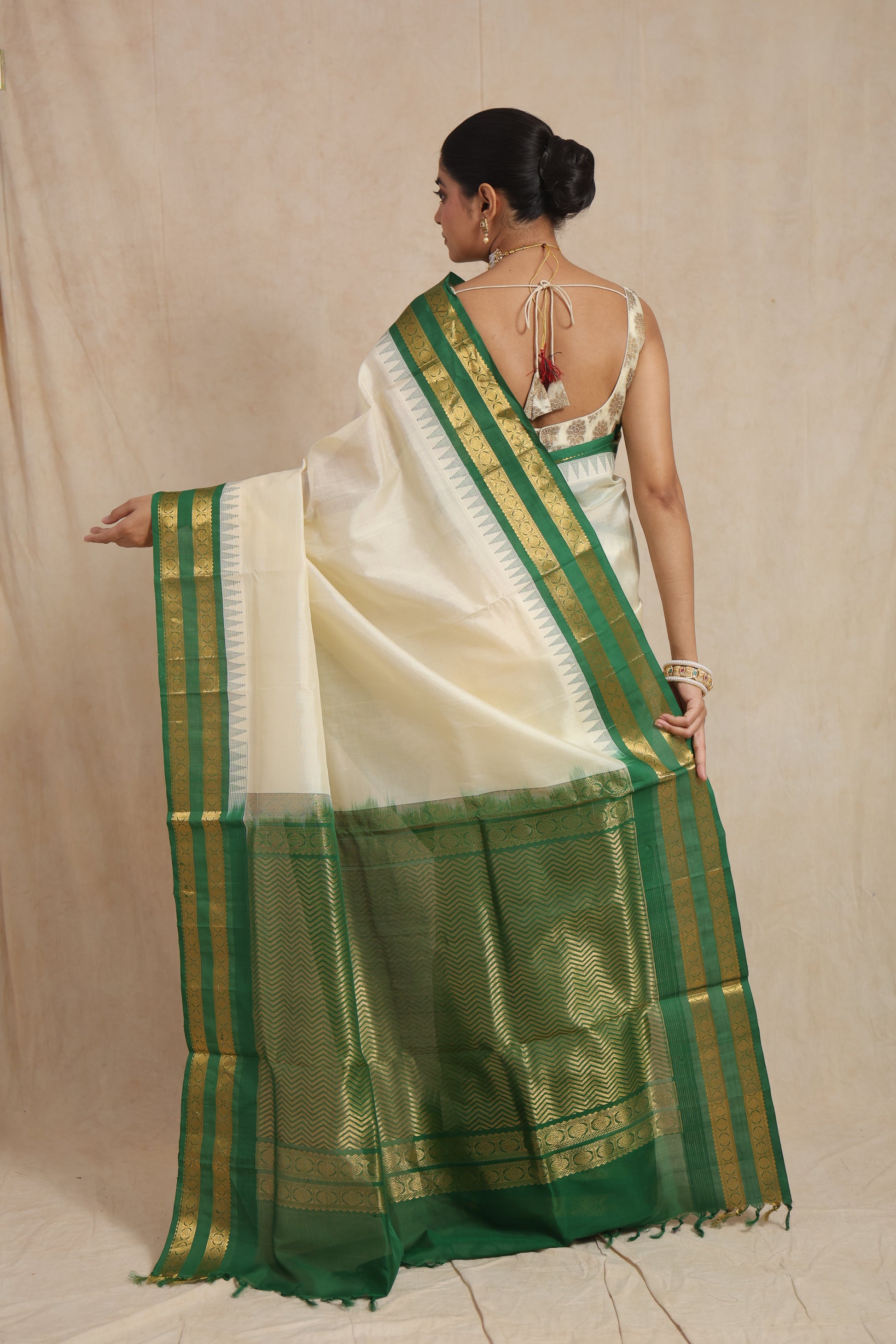 Back drape view of off-white Kanchipuram Sico saree with rich green pallu