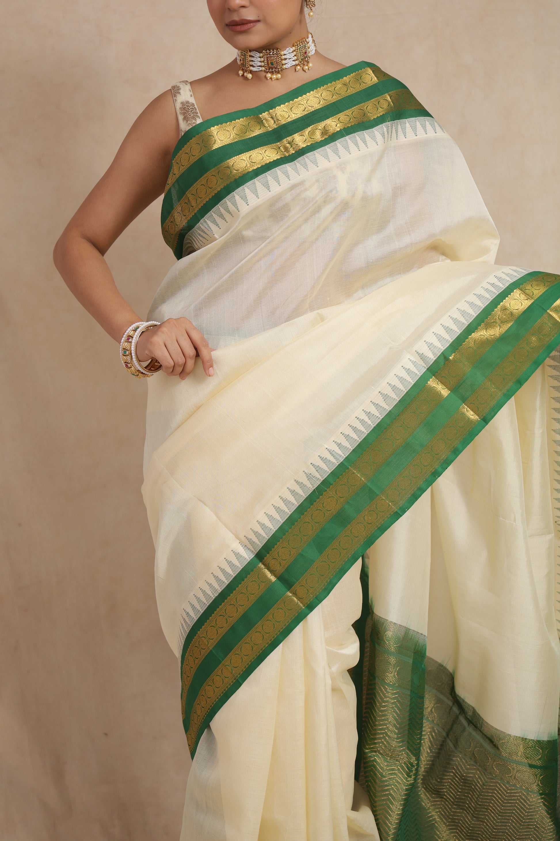 Close-up of off-white Kanchipuram Sico saree featuring emerald green zari woven border