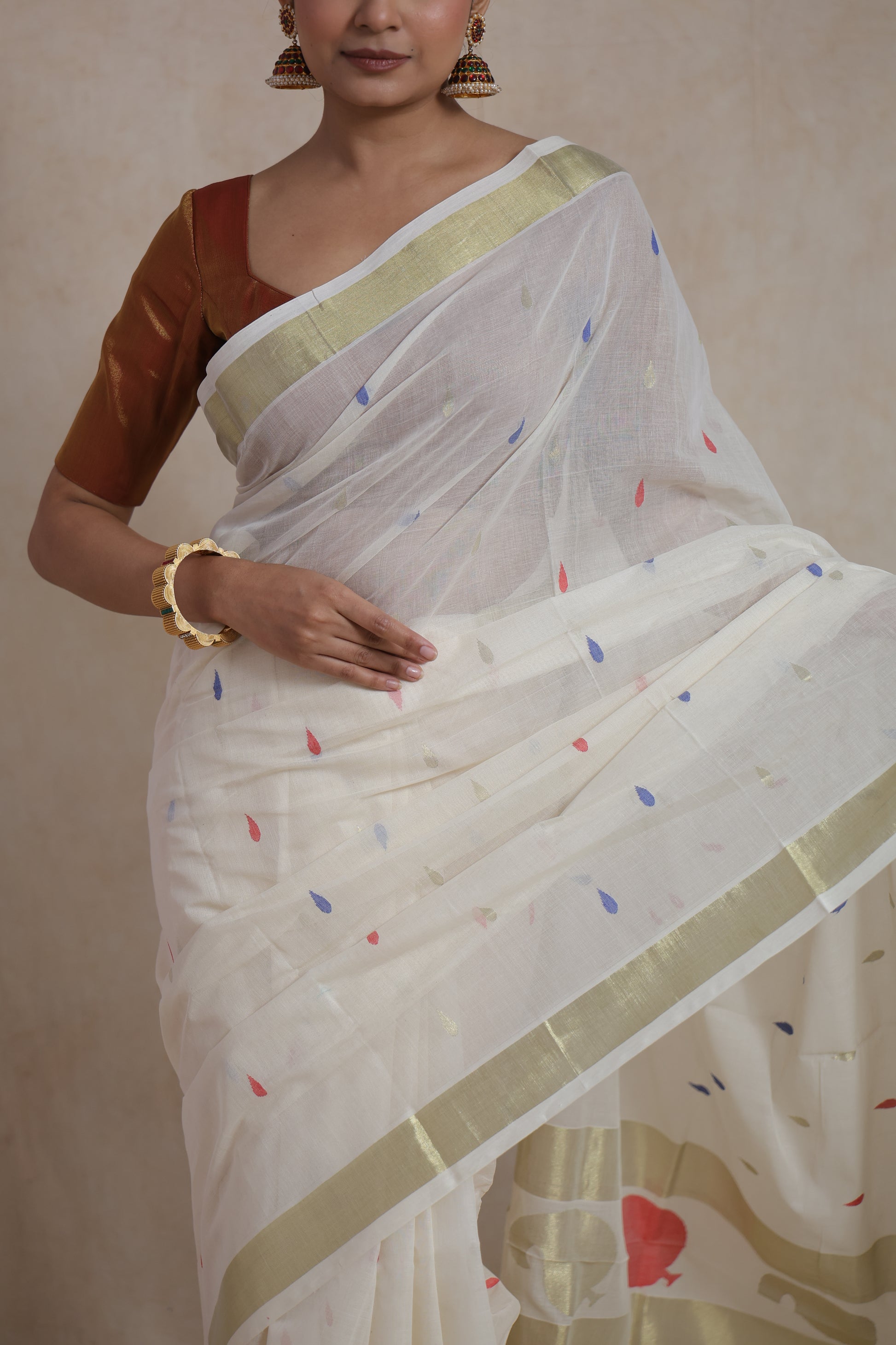 Close-up drape view of off white Kanchipuram cotton saree with multicolor buttas