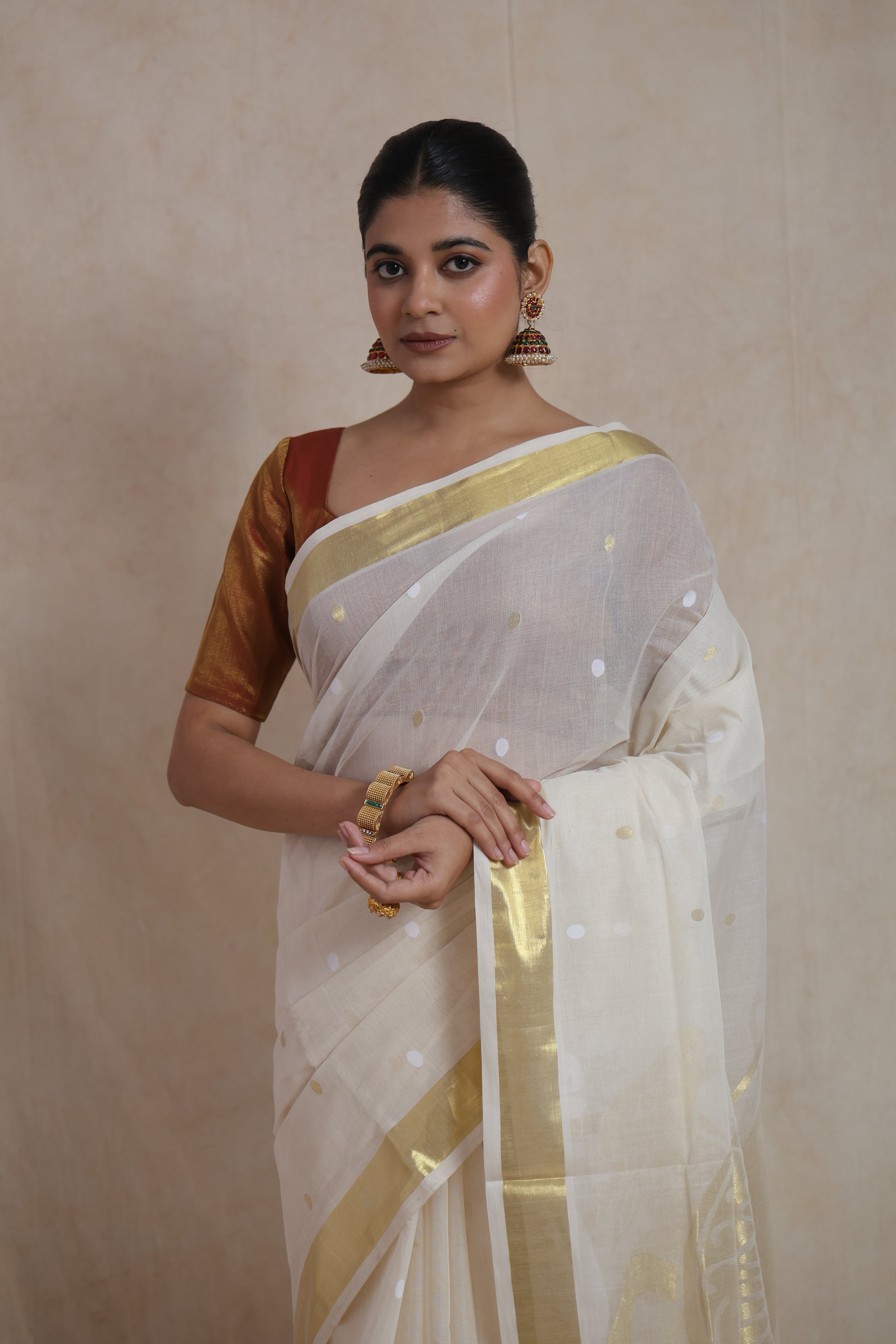 Off white Kanchipuram cotton saree with golden peacock motif pallu