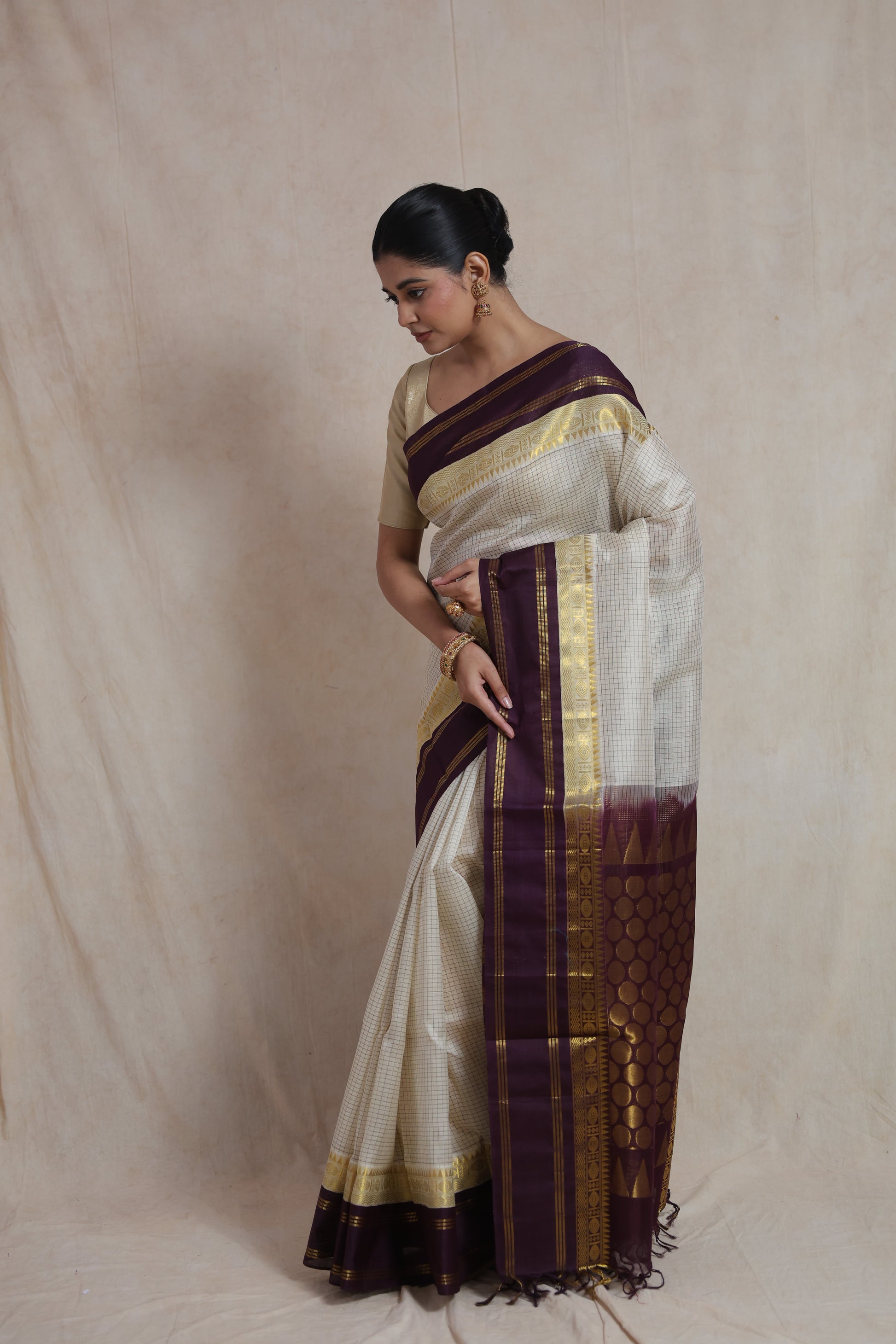 Elegant pose in off white Kanchipuram Sico saree with purple contrast border