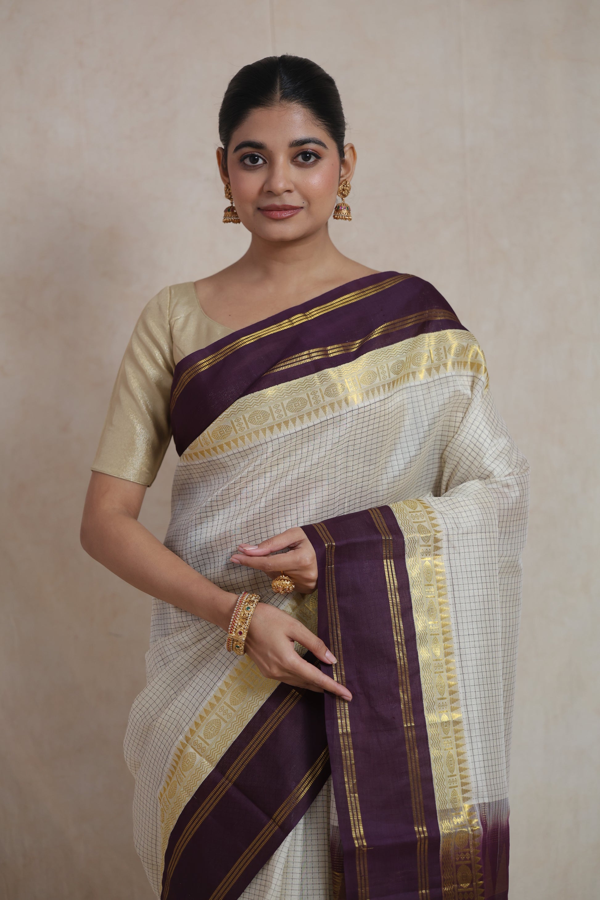 Portrait view of off white Kanchipuram Sico saree with traditional zari detailing