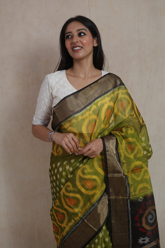Portrait view of olive green Pochampally silk cotton saree with classic Ikat weave and zari border