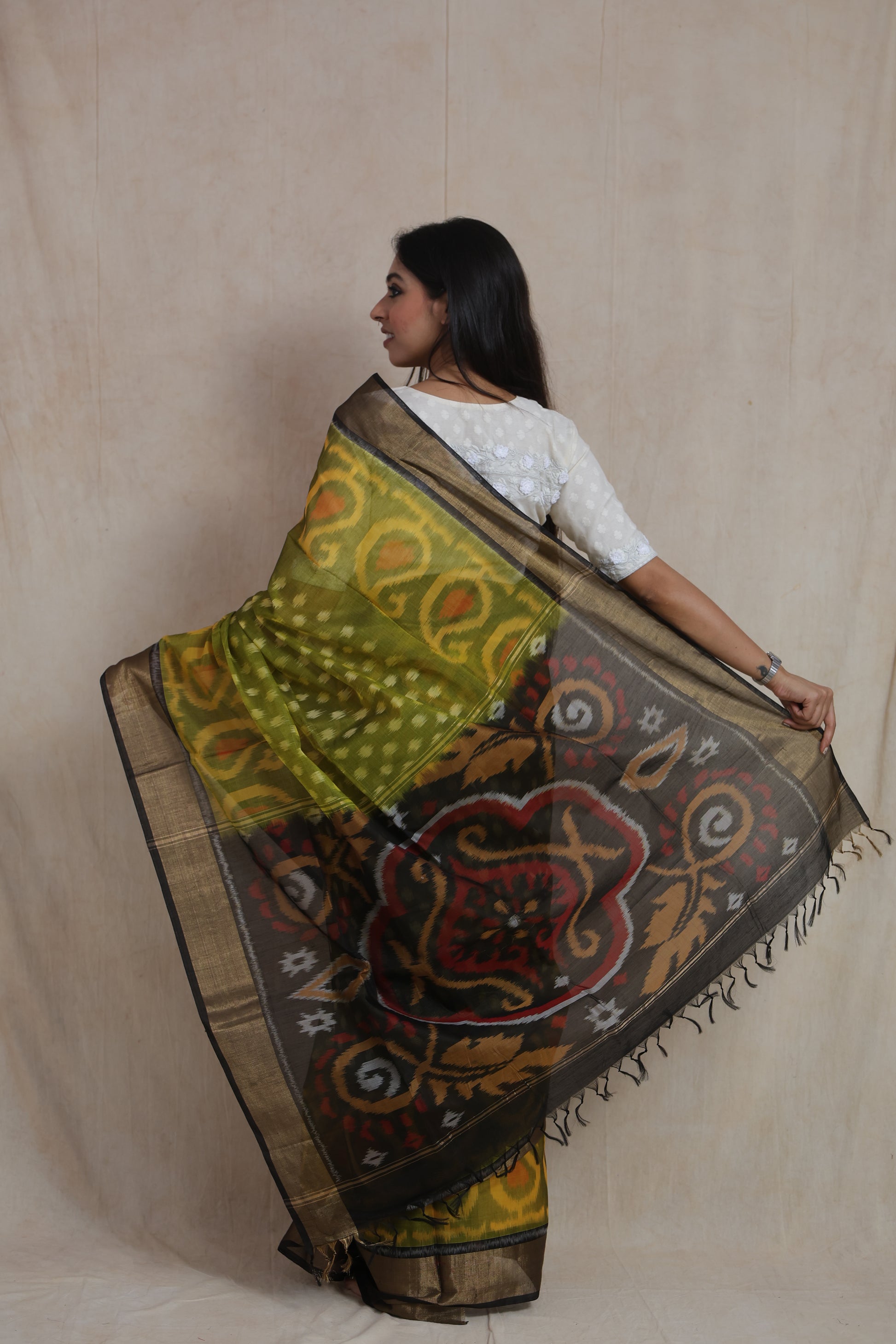 Back drape view of olive green Pochampally silk cotton saree featuring artistic woven pallu design