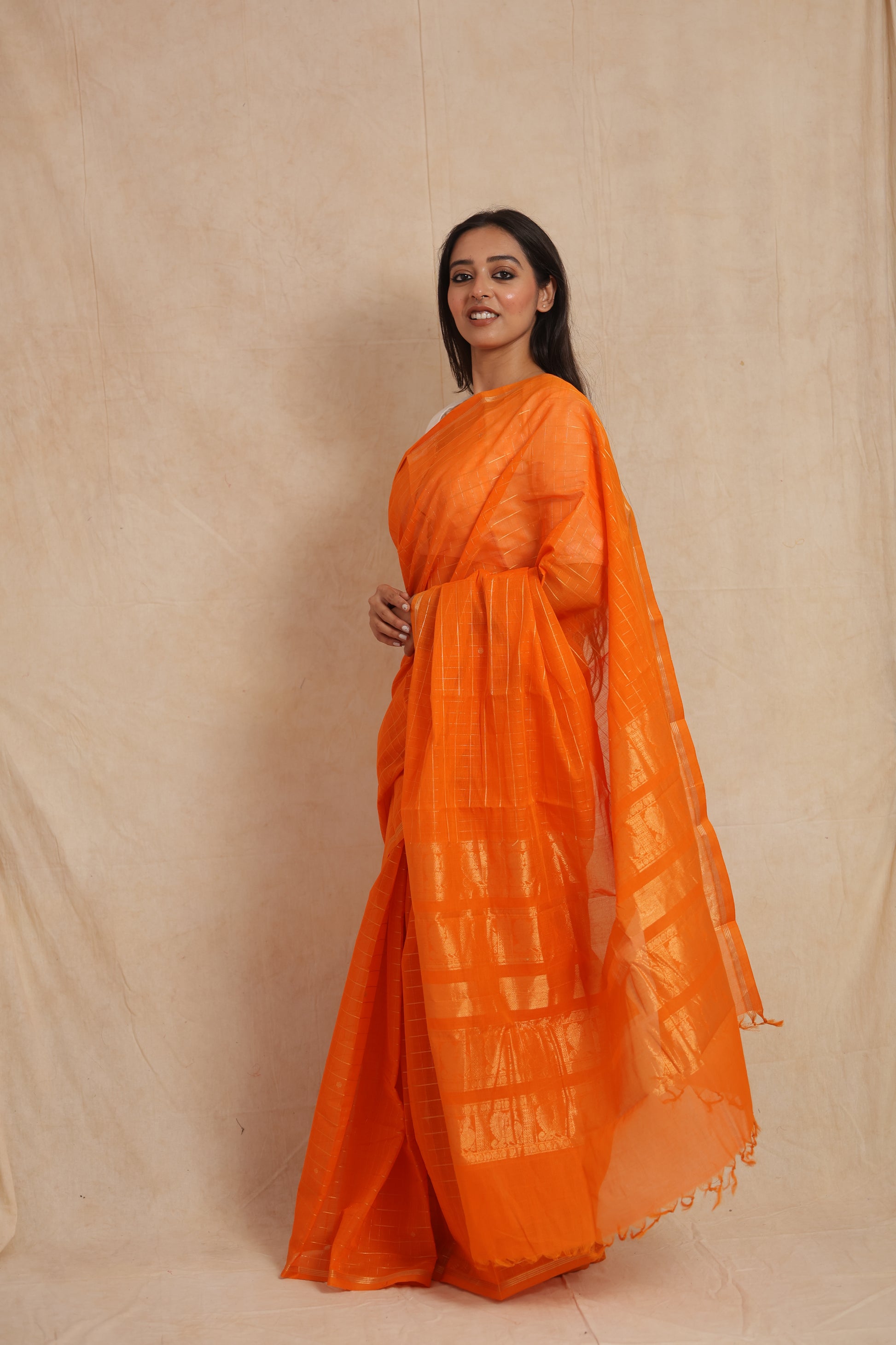Side profile of orange Kanchipuram cotton saree with elegant woven pallu