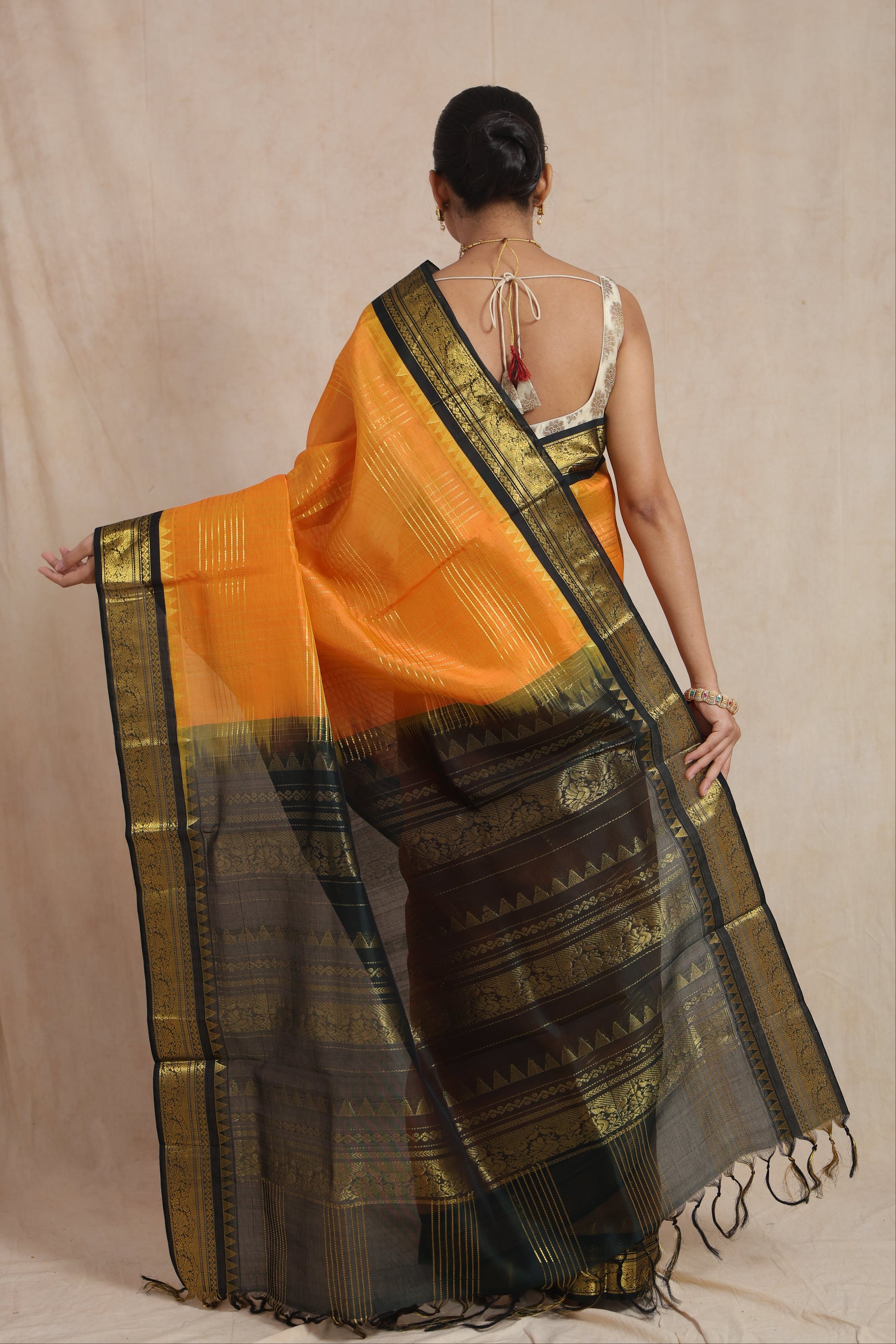 Back drape view of orange Kanchipuram Sico saree with rich woven pallu