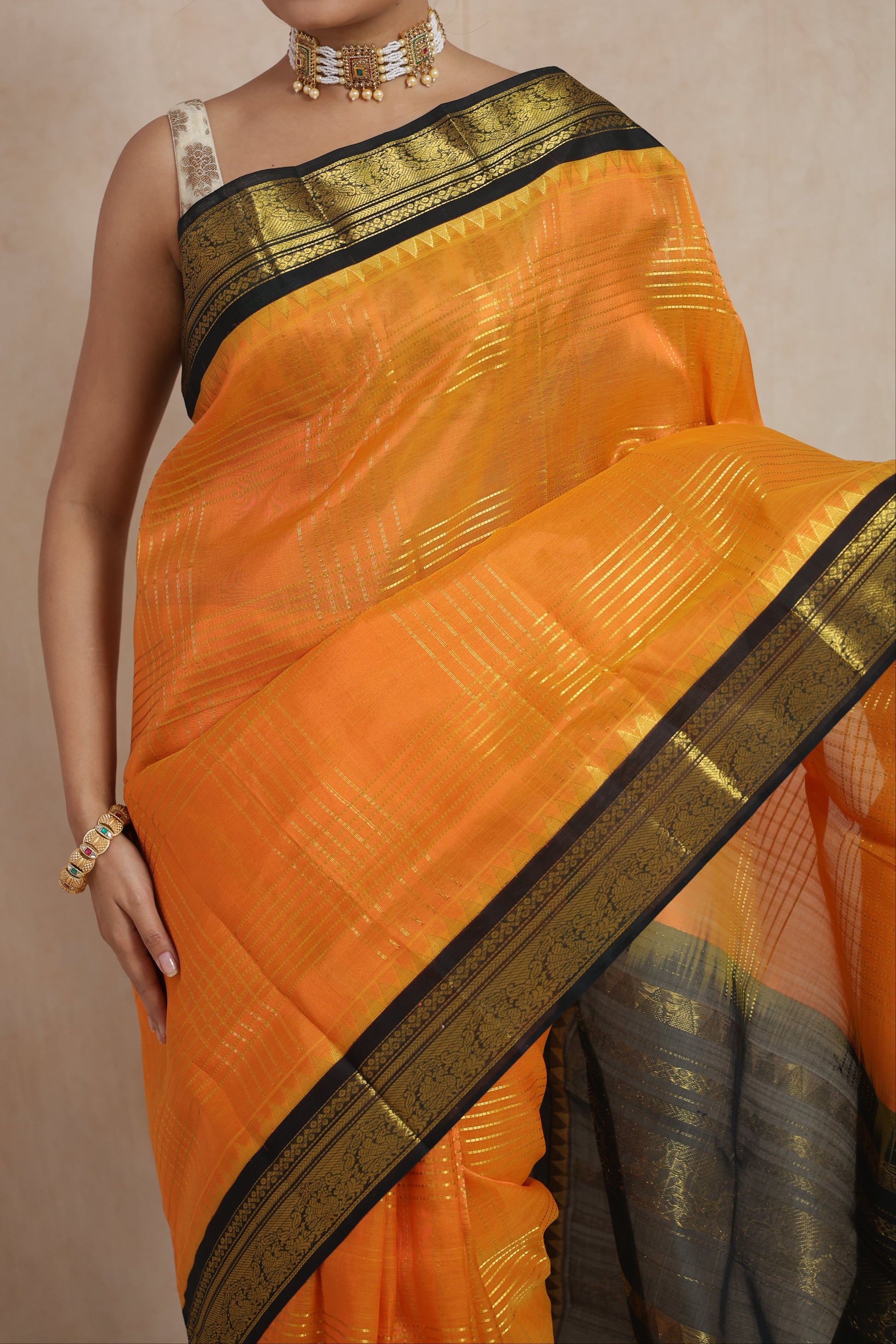 Close-up of black zari woven border on orange Kanchipuram Sico saree
