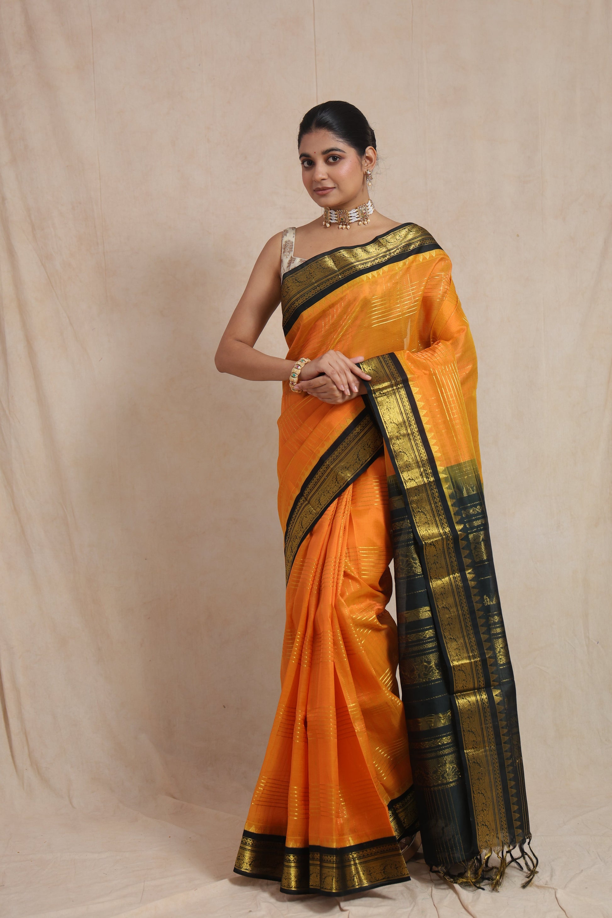 Full view of orange Kanchipuram Sico saree with black zari border