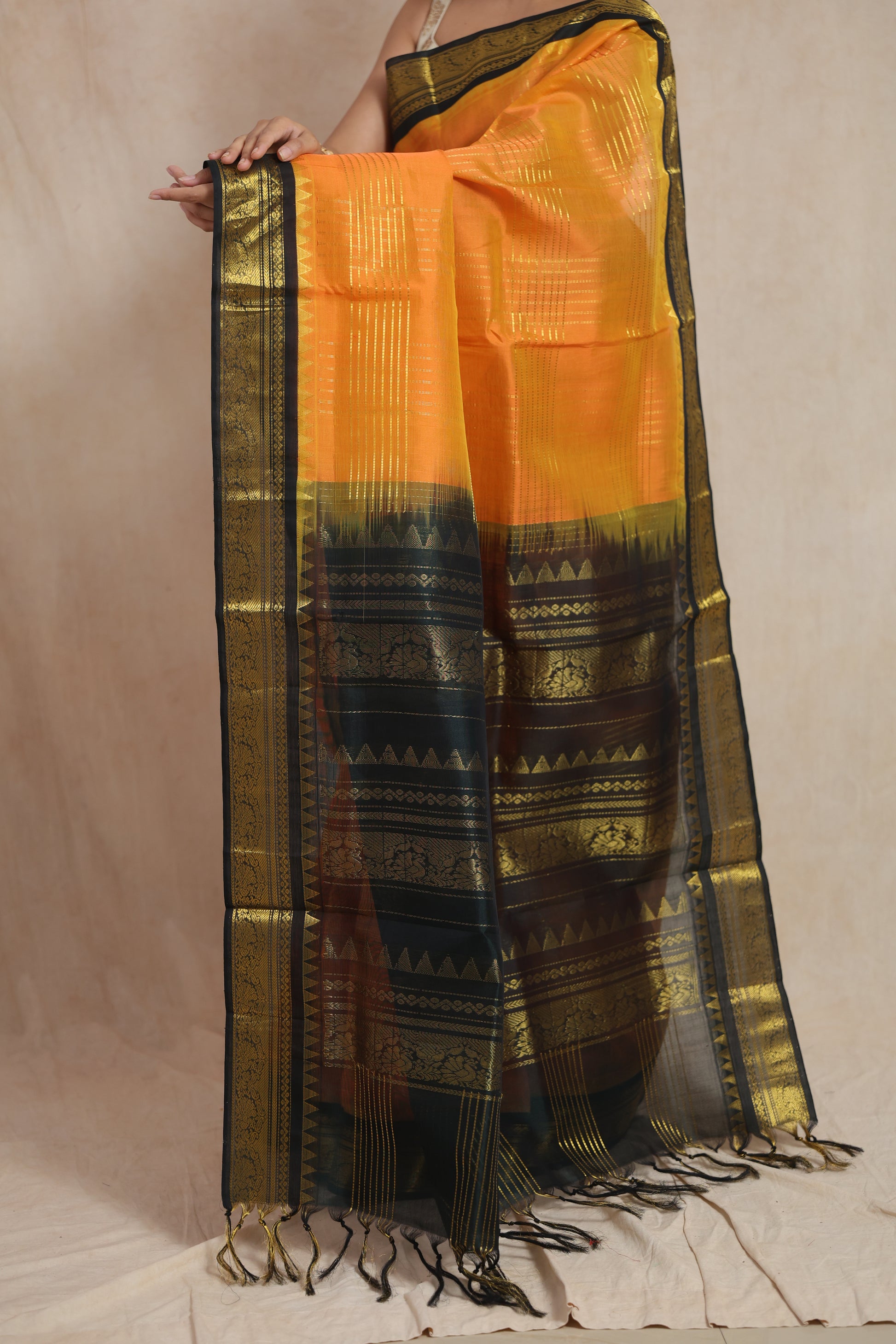 Detailed pallu view of orange Kanchipuram Sico saree with black and gold zari weaving