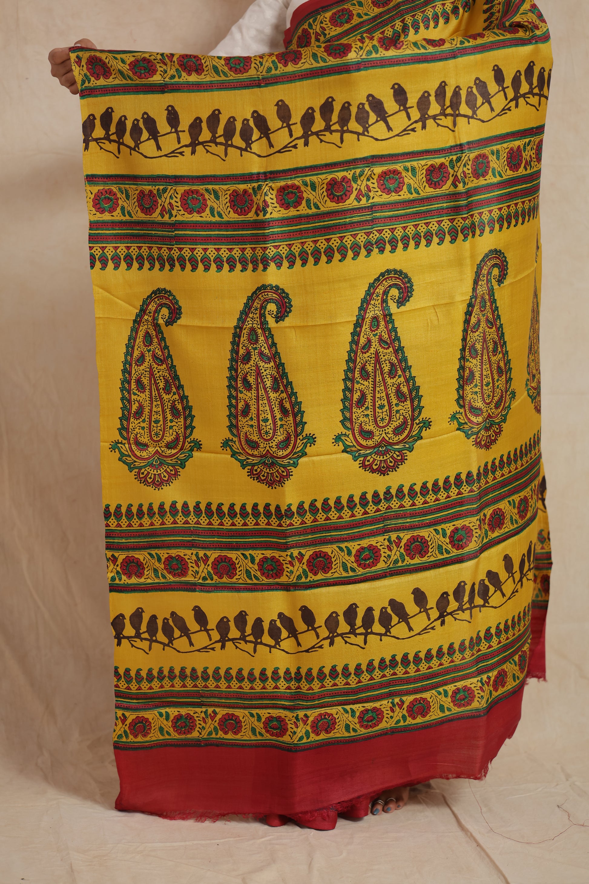 Detailed pallu design of sunshine yellow Tussar saree featuring bird and paisley prints