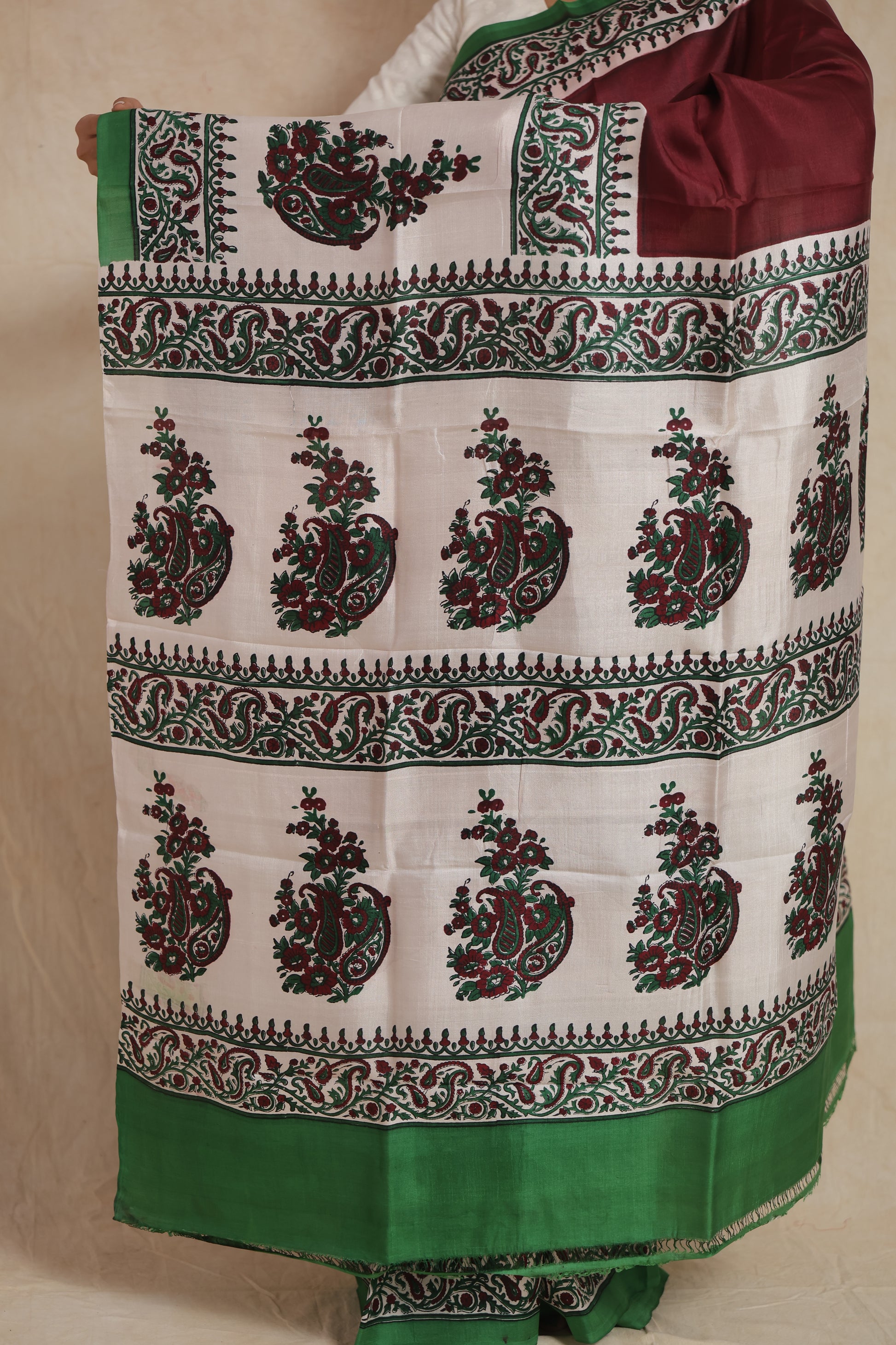 Detailed pallu of maroon Batik silk saree with floral paisley prints and green border