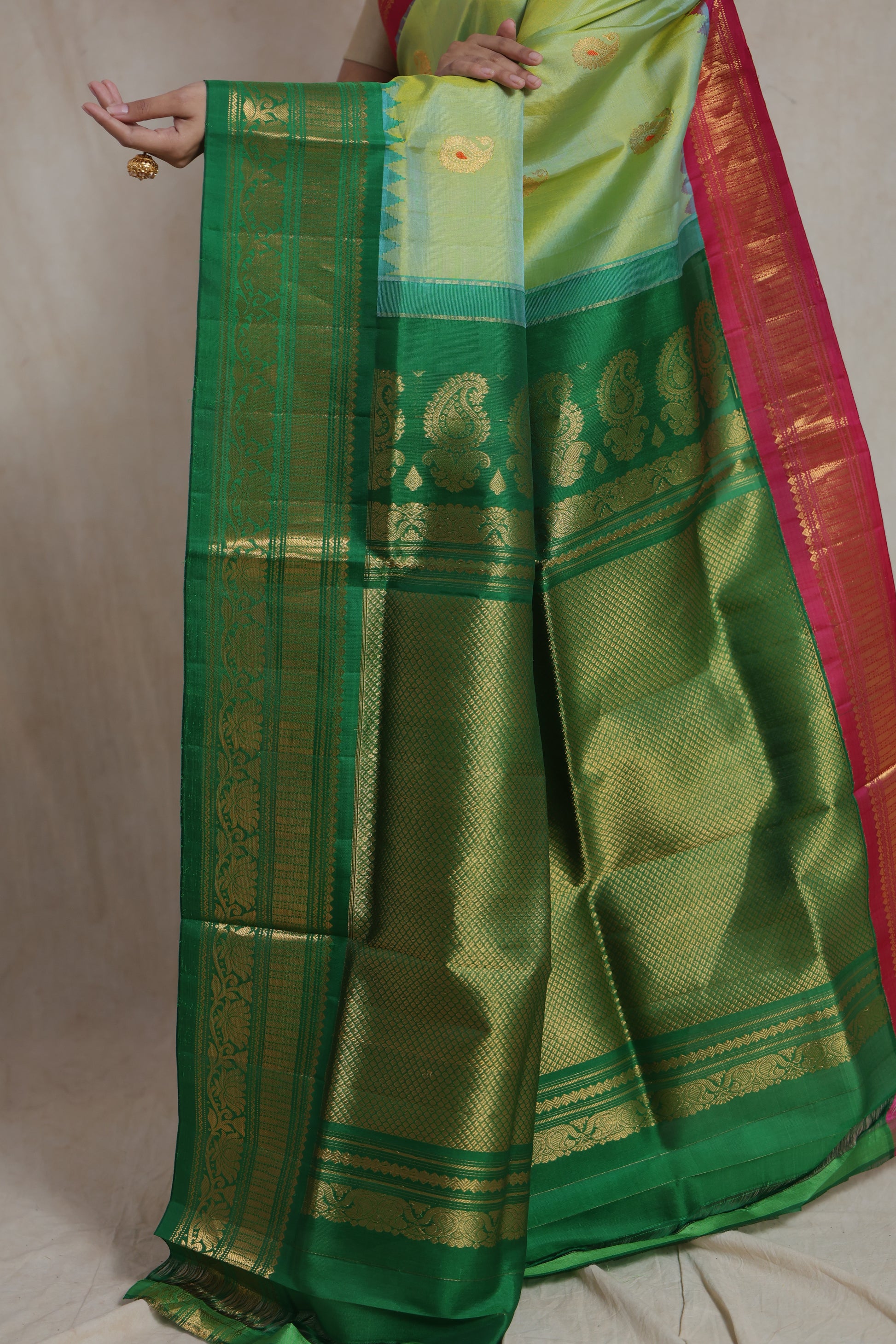 Traditional drape of pastel lime green Gadwal Sico saree with rich pallu