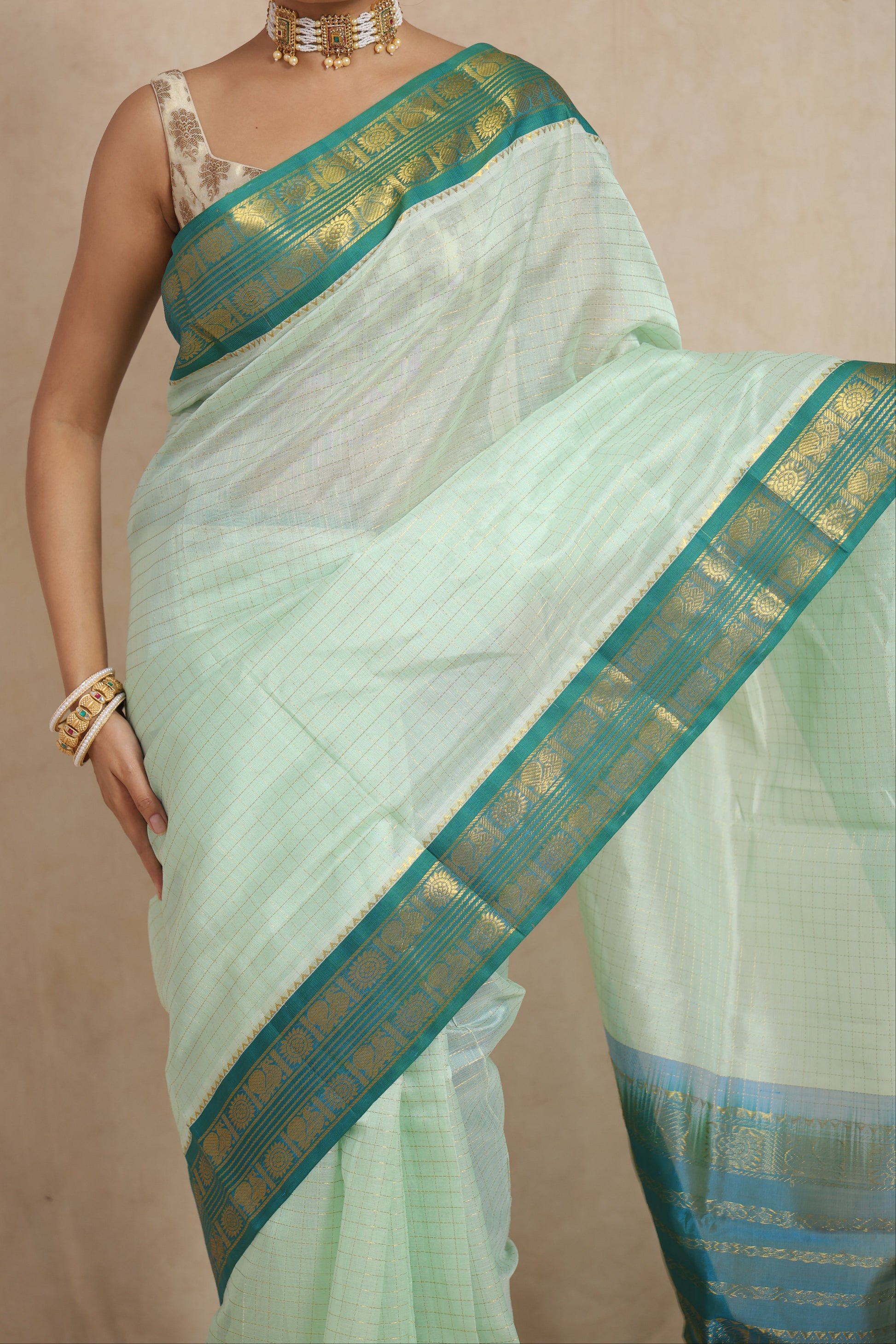 Border detail of pastel mint green Kanchipuram Sico saree featuring teal blue zari weaving