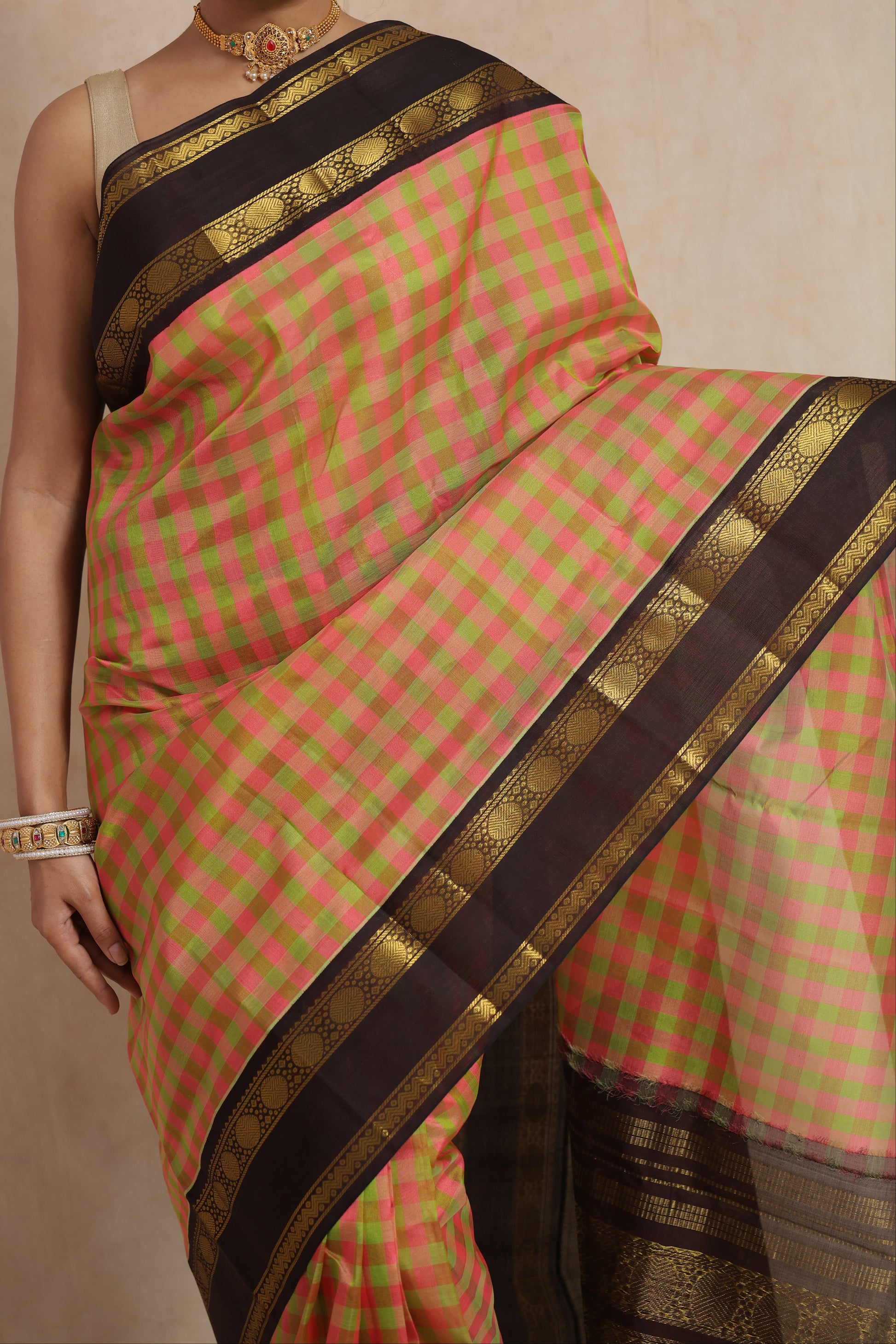 Close-up of pastel pink and olive checked Kanchipuram Sico saree with black zari border