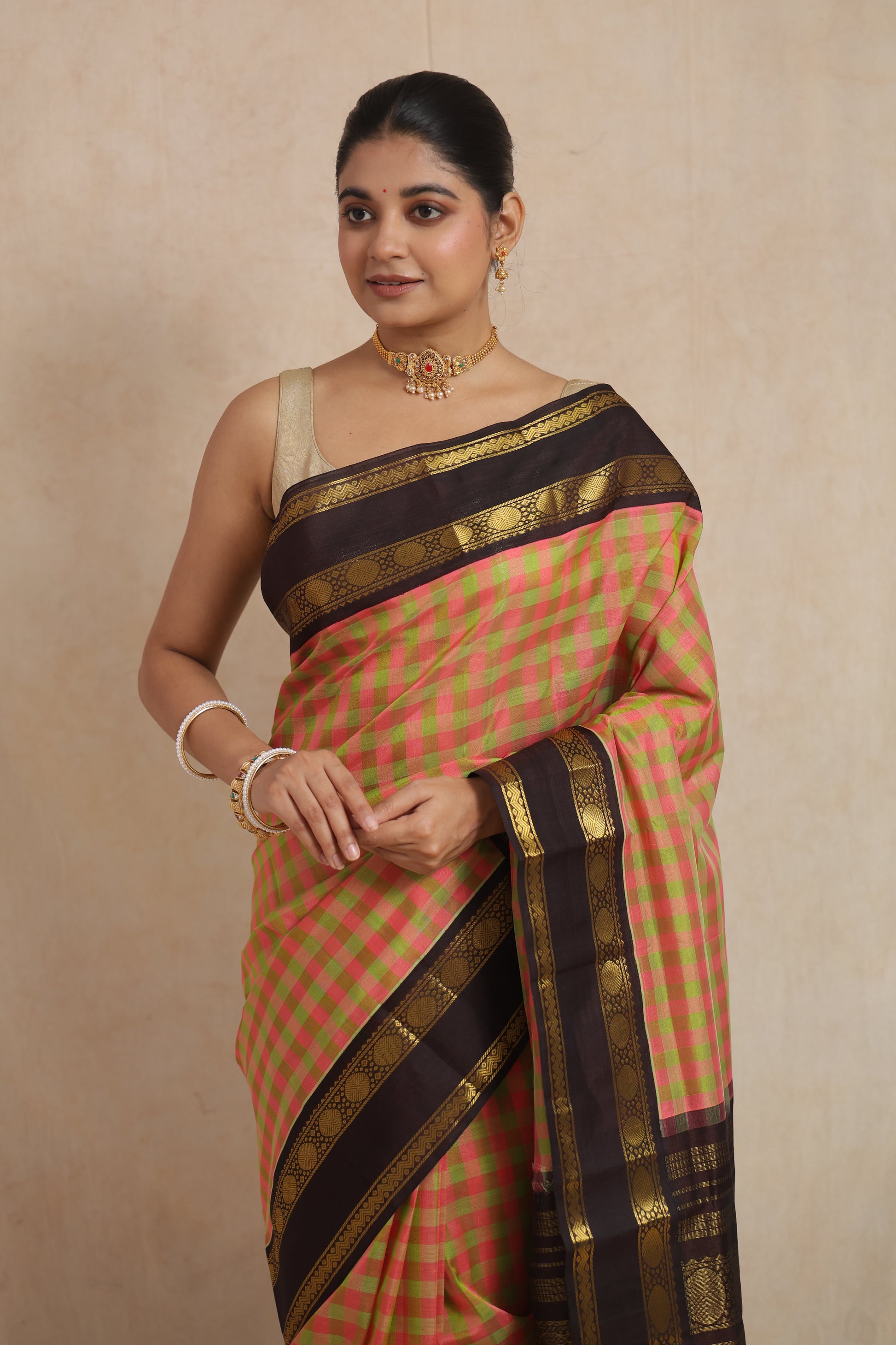 Front look of pastel pink checked Kanchipuram Sico saree with traditional woven border