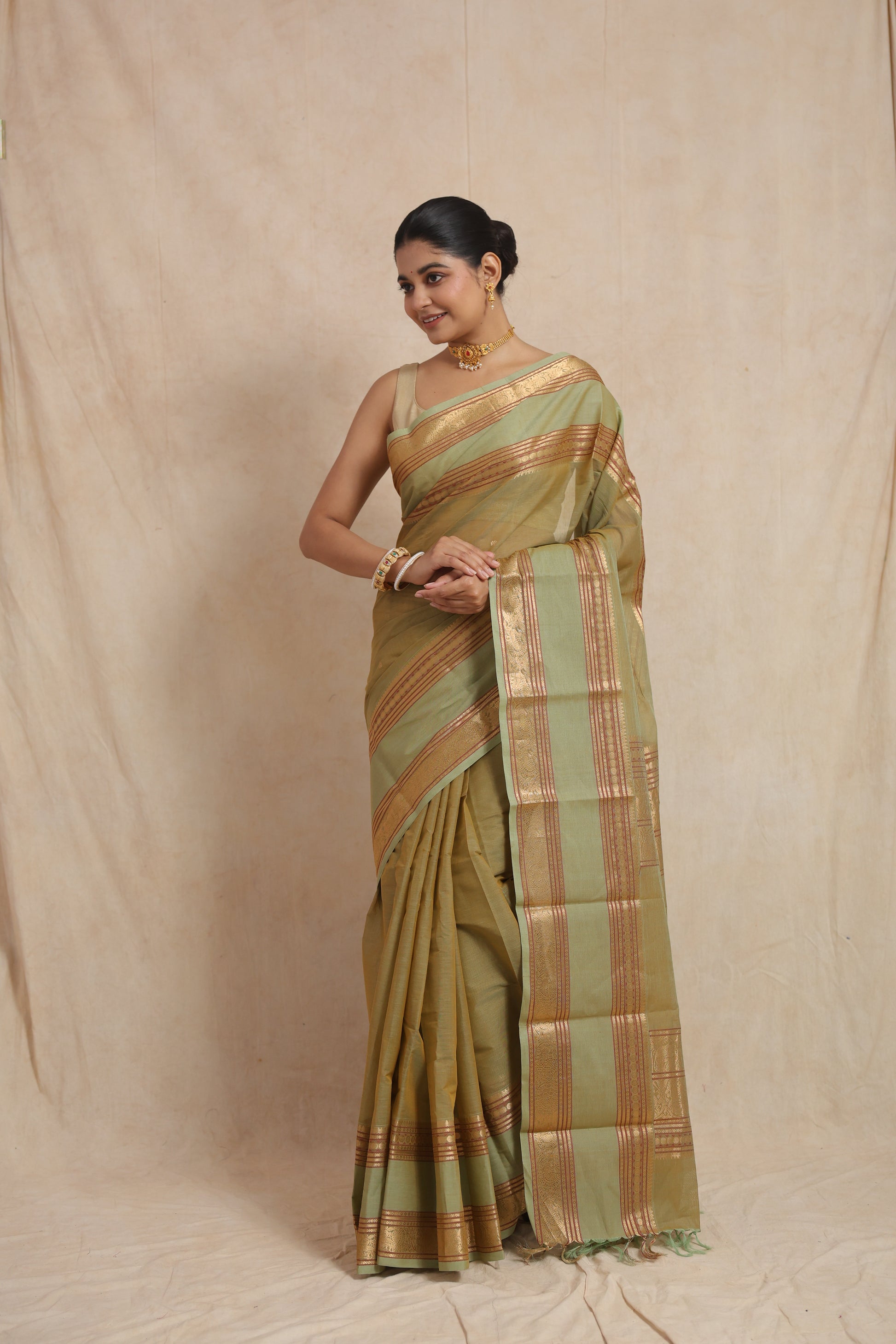 Elegant pose in pastel sage green Kanchipuram cotton saree