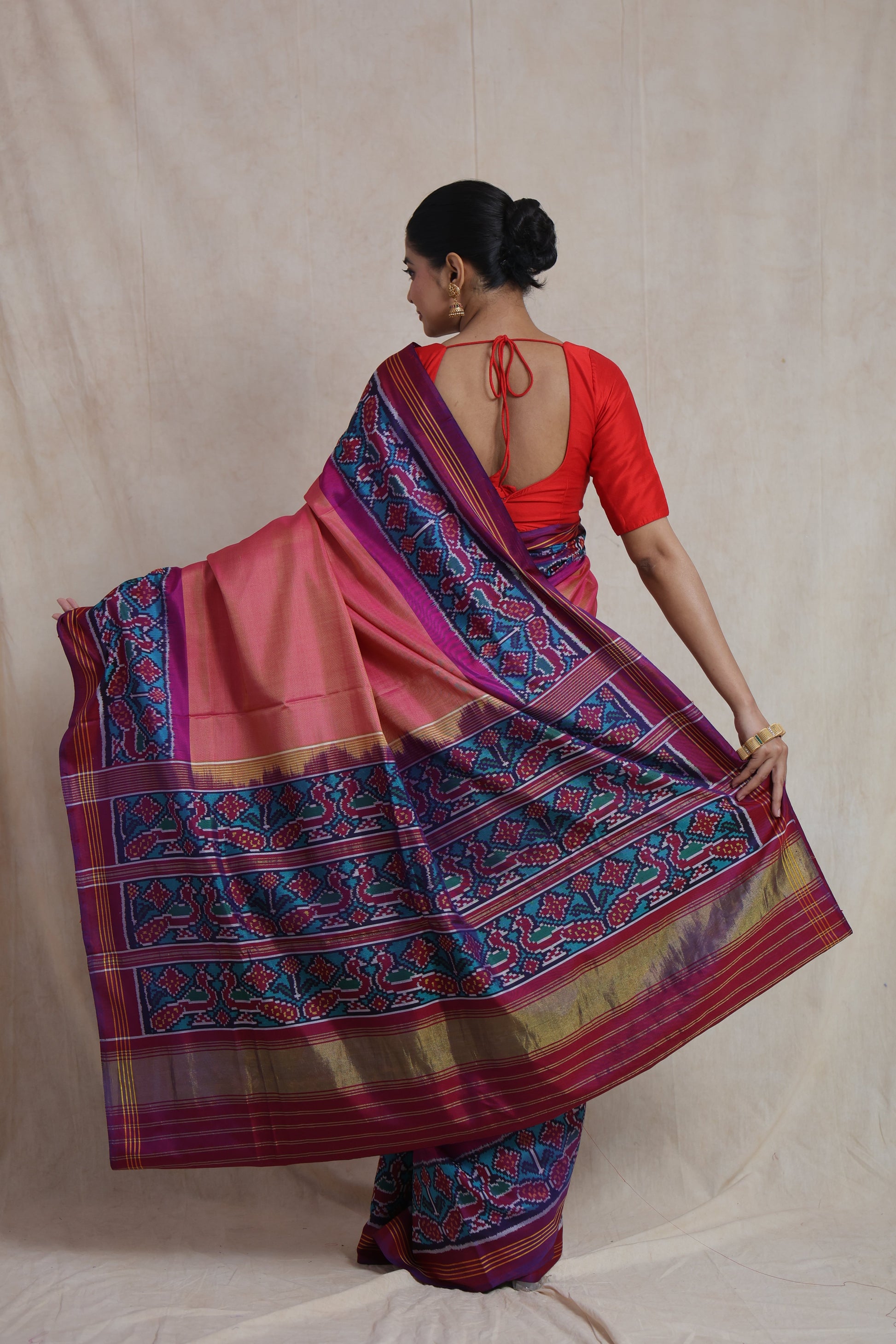 Back view of blush pink Patola handloom silk saree showcasing richly woven multicolor pallu