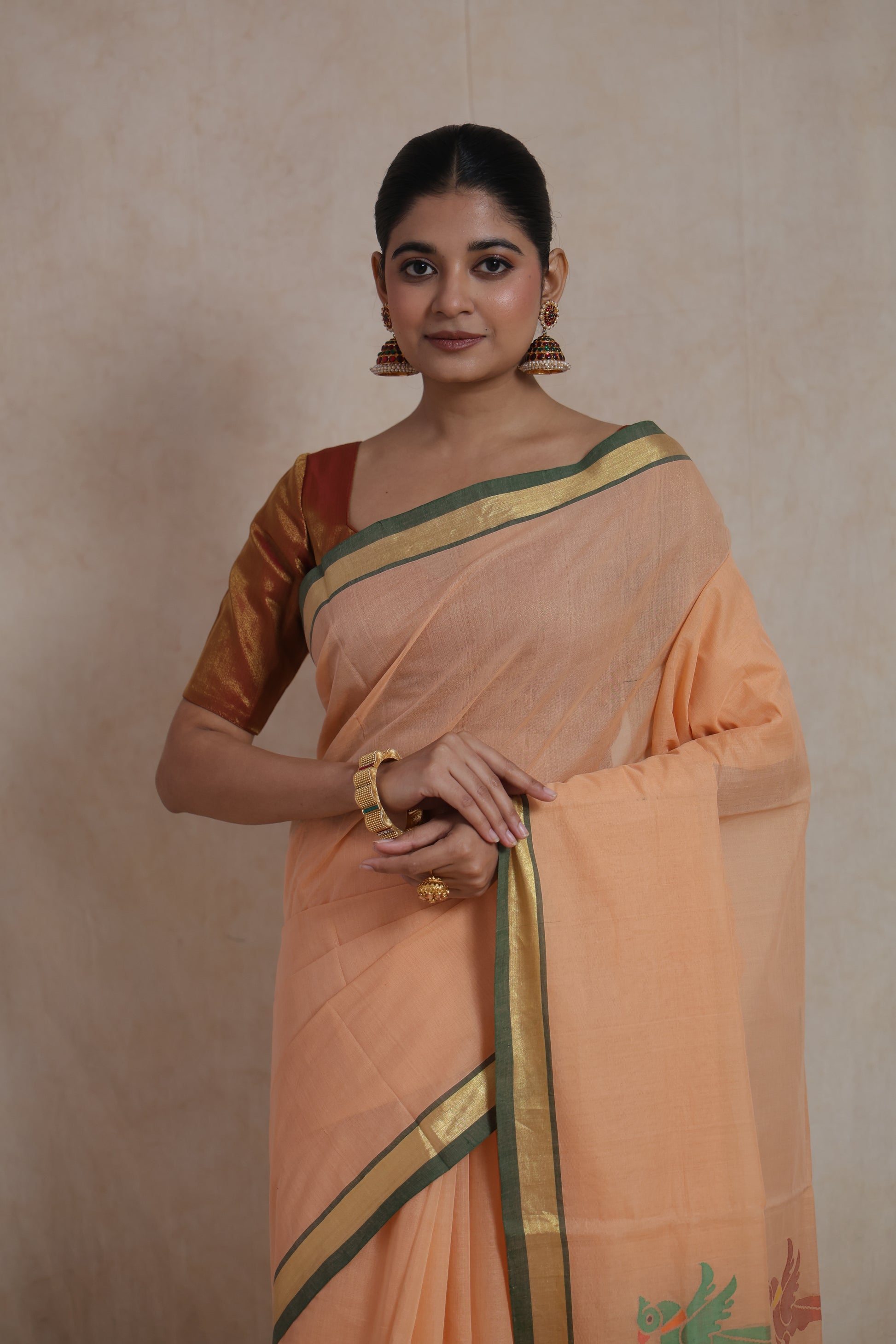 Close-up view of peach Kanchipuram cotton saree with zari border