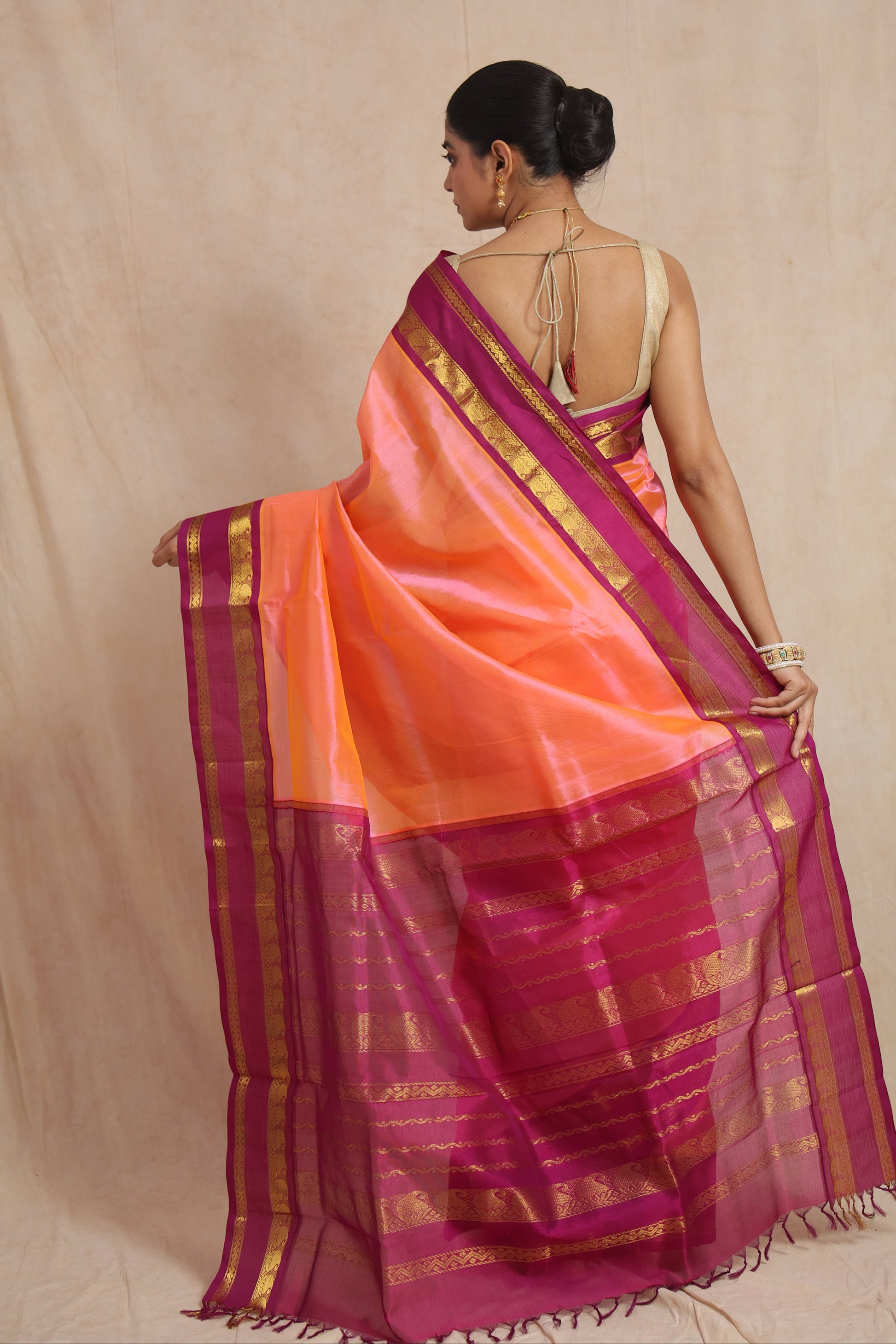 Back view of peach orange Kanchipuram Sico saree with rani pink zari border