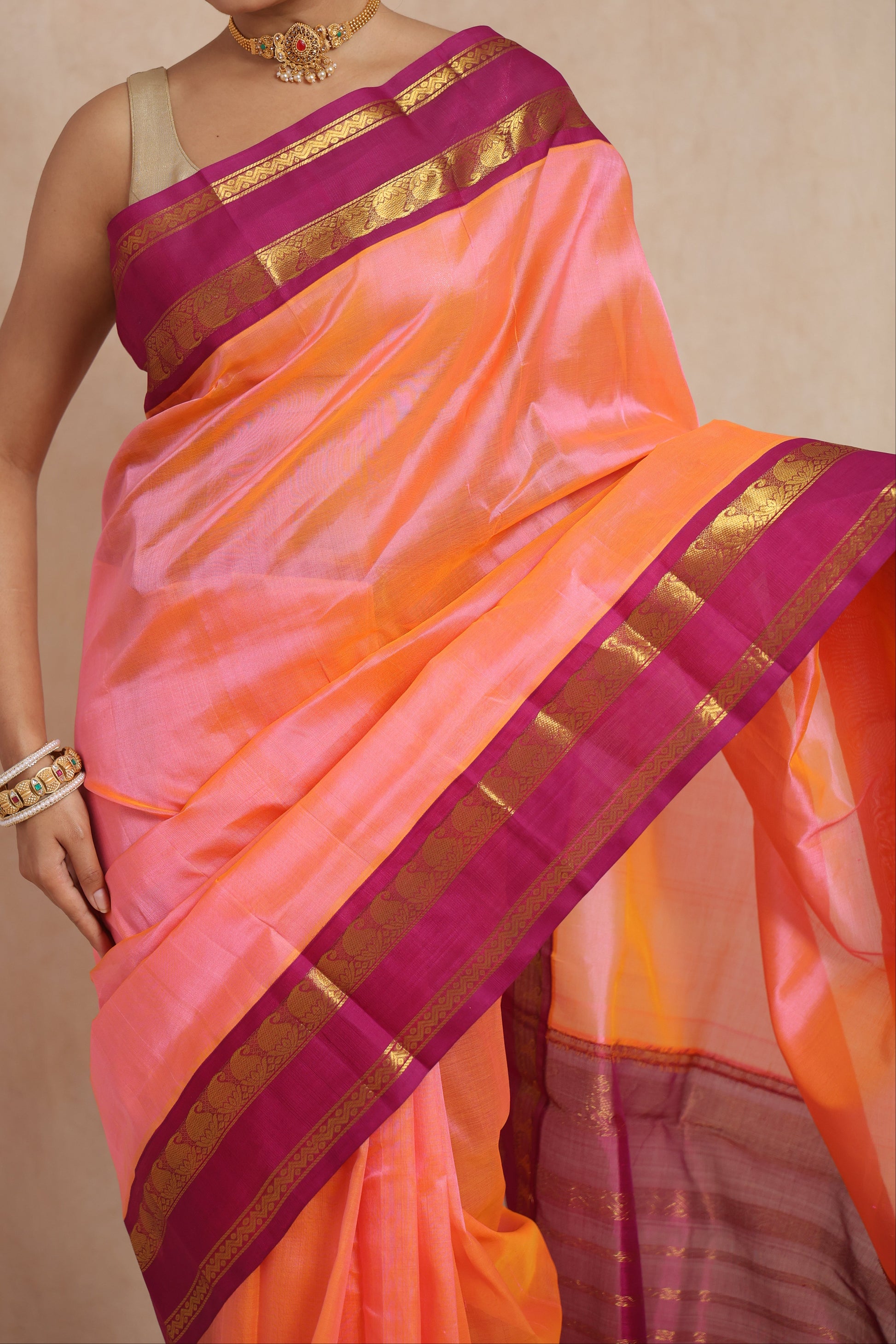 Close-up of peach orange Kanchipuram Sico saree with pink contrast border