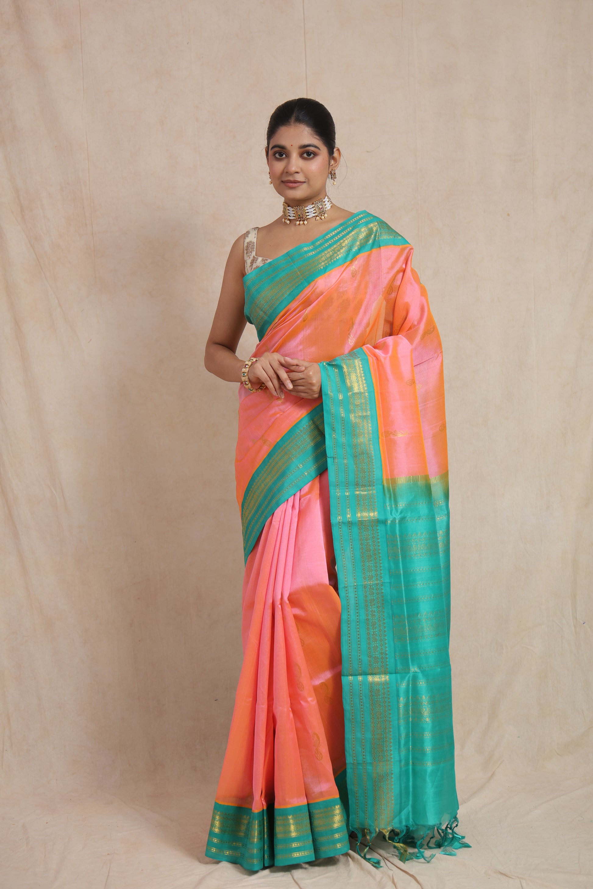 Front view of elegant peach pink Kanchipuram Sico saree with turquoise blue pallu