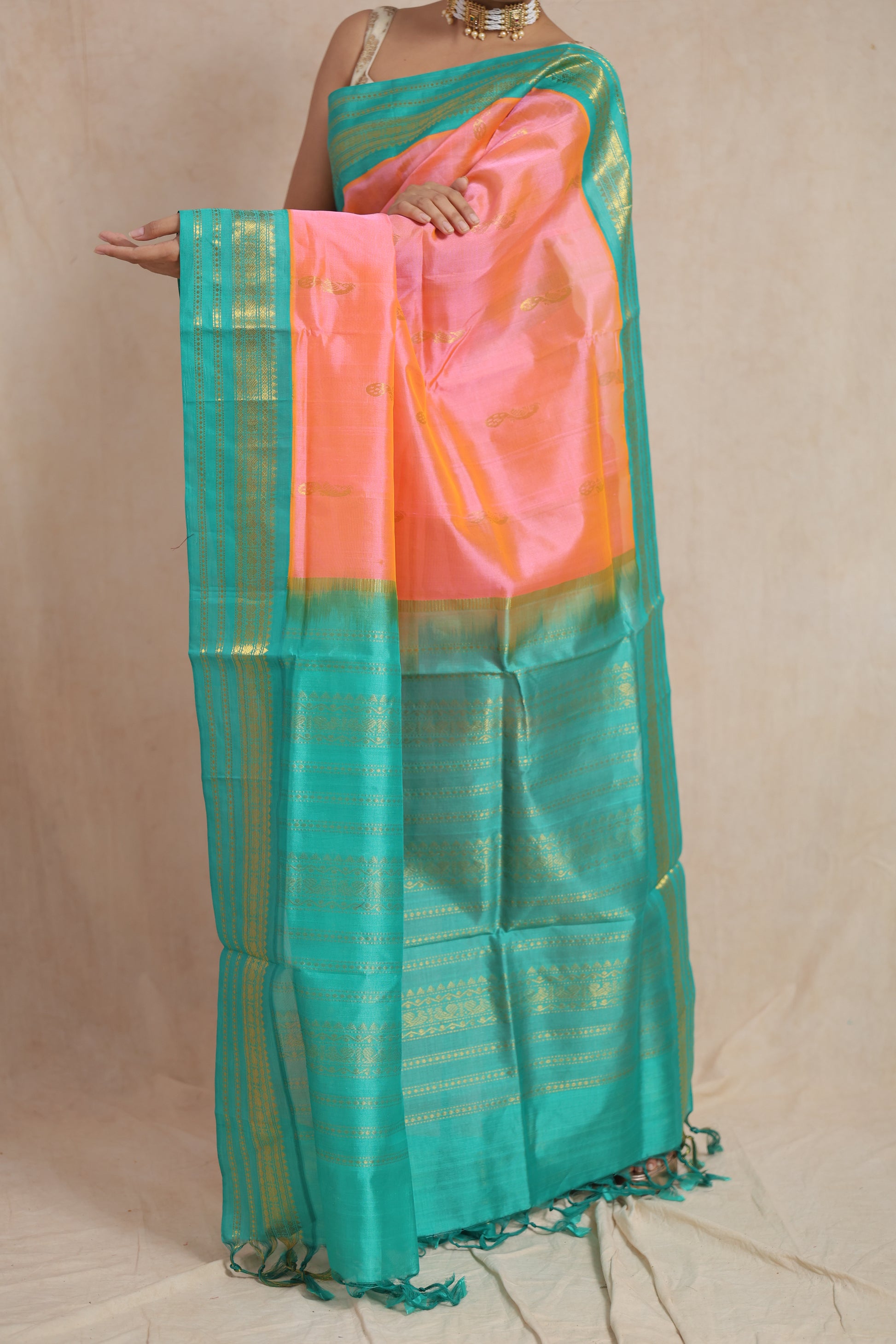 Full drape view of peach pink Kanchipuram Sico saree with turquoise blue zari woven border