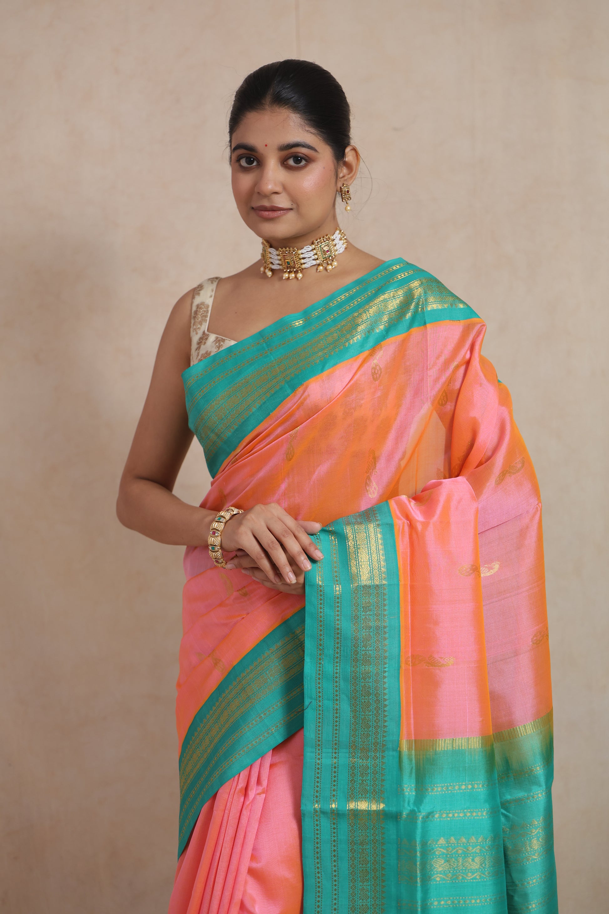 Portrait view of handwoven peach pink Kanchipuram Sico saree with traditional detailing