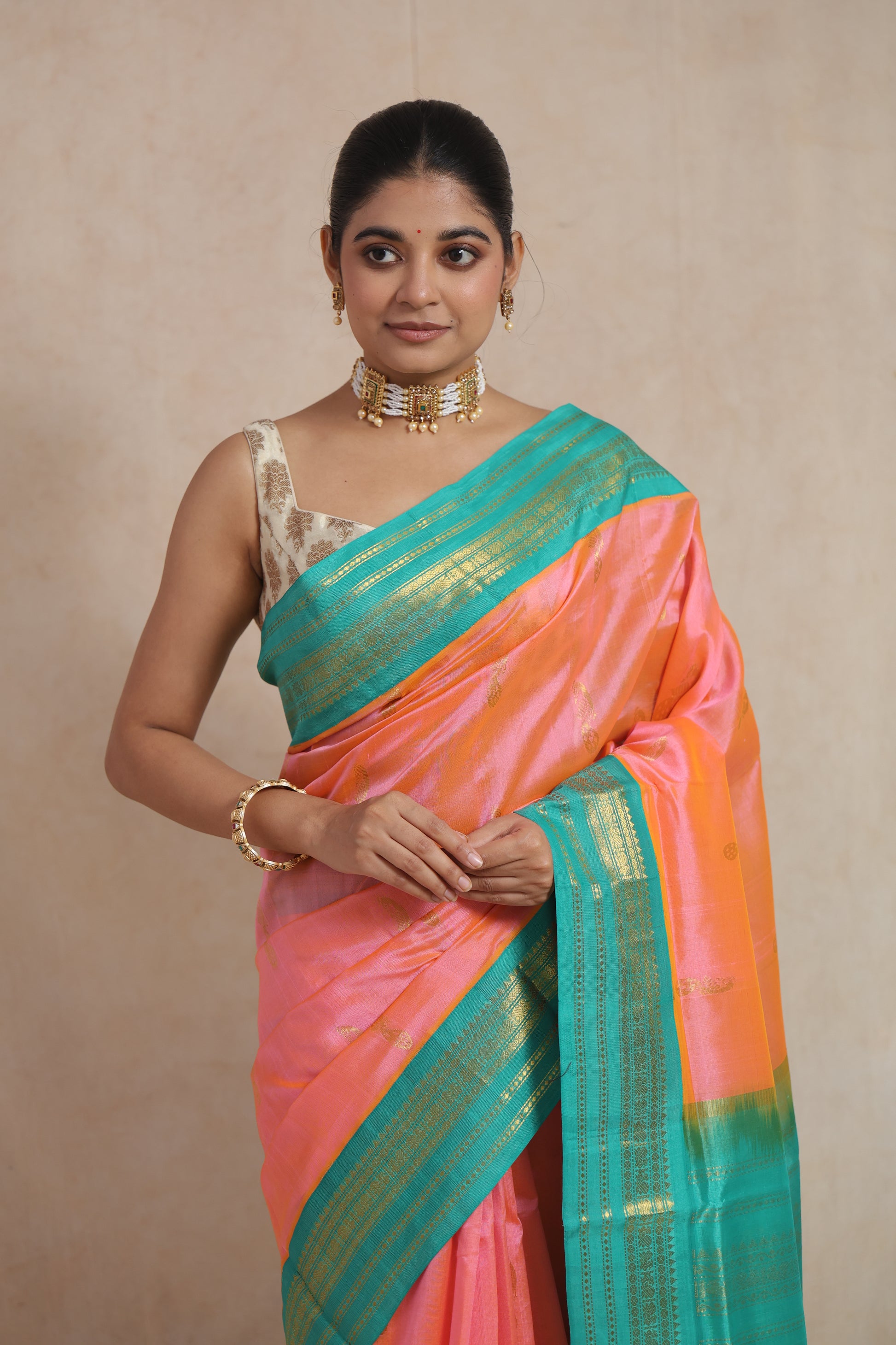 Portrait view of handwoven peach pink Kanchipuram Sico saree with rich woven detailing