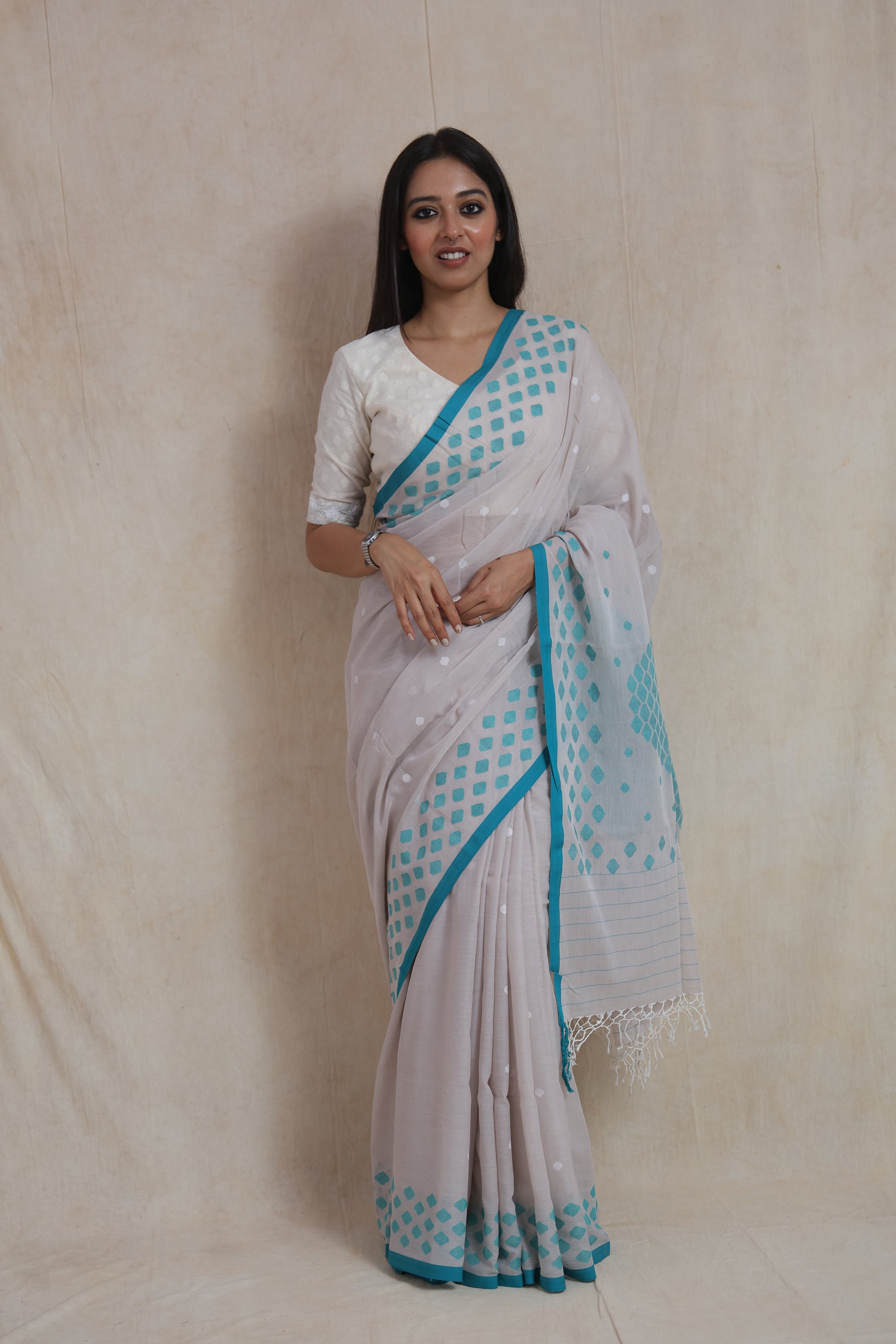 Front view of pearl grey Bengal Cotton Fulia saree with aqua blue geometric woven border