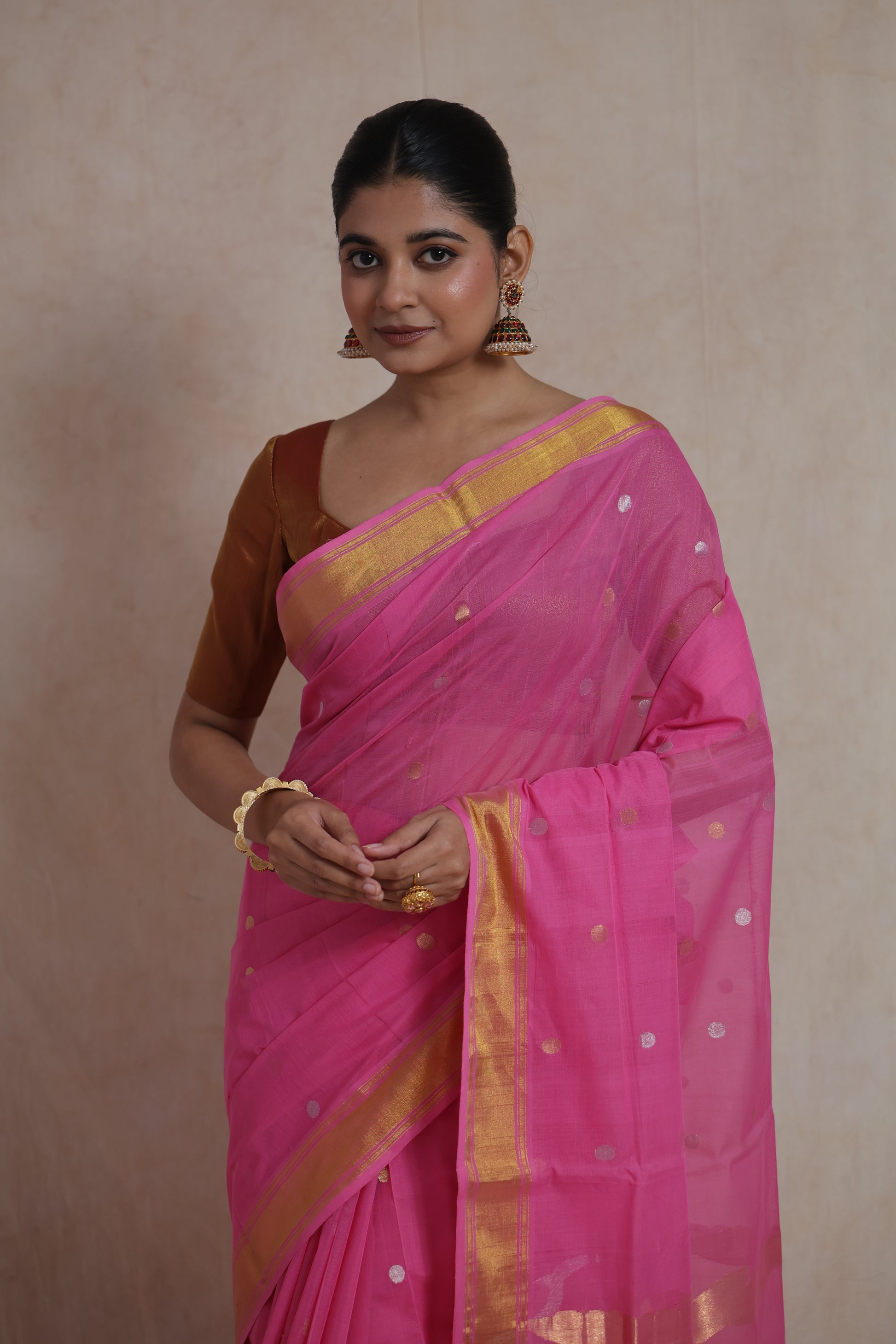 Close-up of pink Kanchipuram cotton saree with golden zari buttas