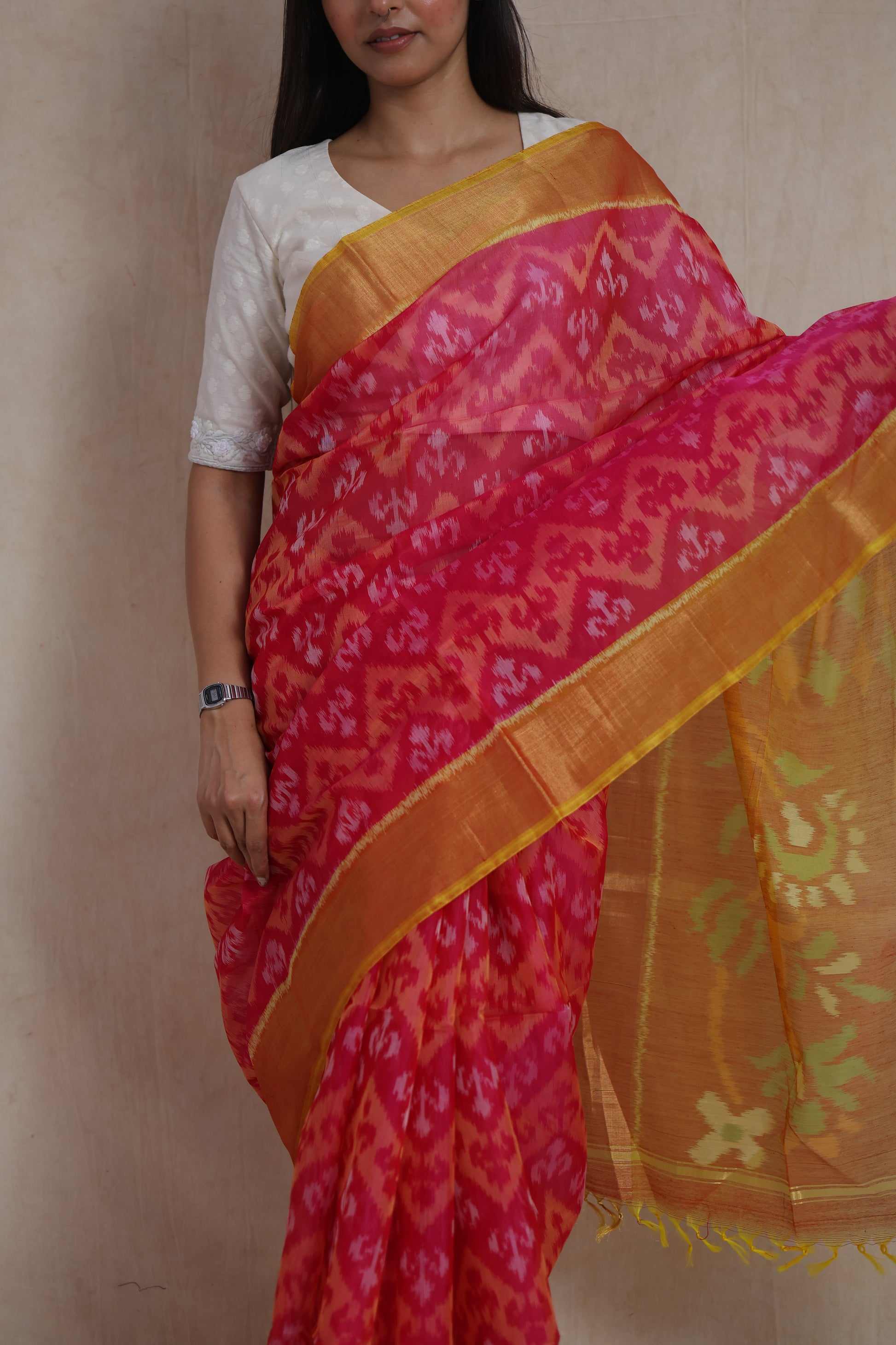 Close-up of Rani pink Pochampally silk cotton saree featuring traditional Ikat patterns