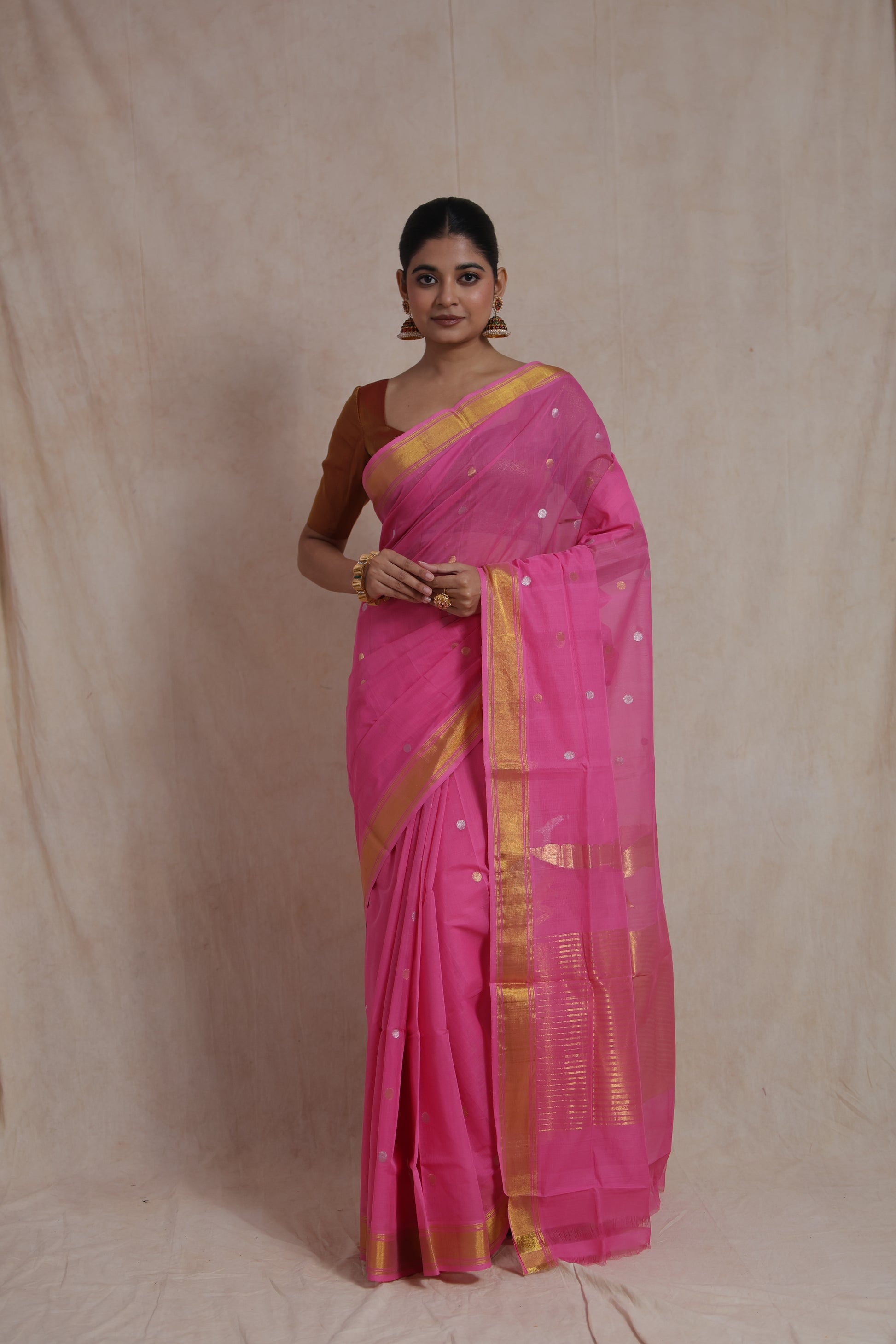 Front view of pink Kanchipuram cotton saree with golden zari border