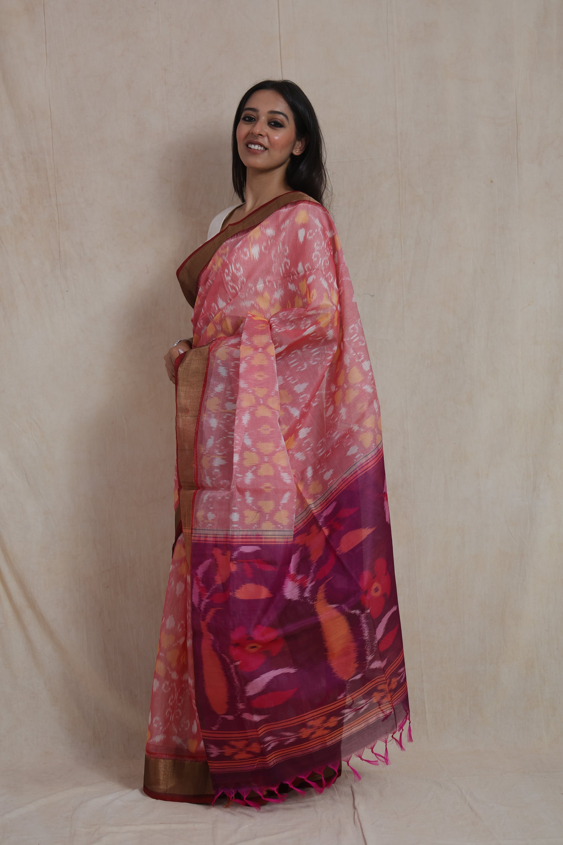 Back drape view of pink Pochampally silk cotton saree with artistic floral pallu design