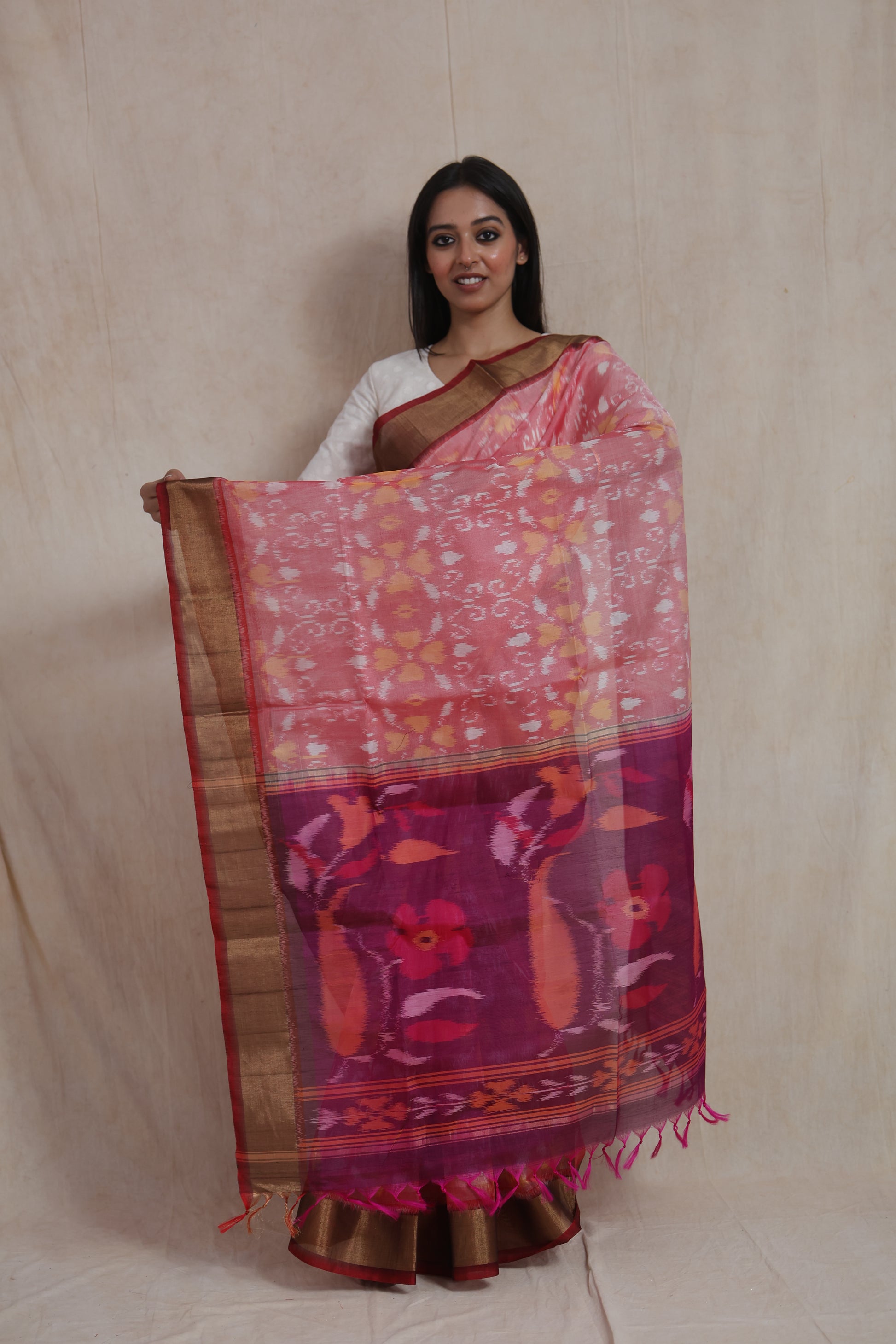 Drape close-up of pink Pochampally silk cotton saree with intricate Ikat motifs and zari border