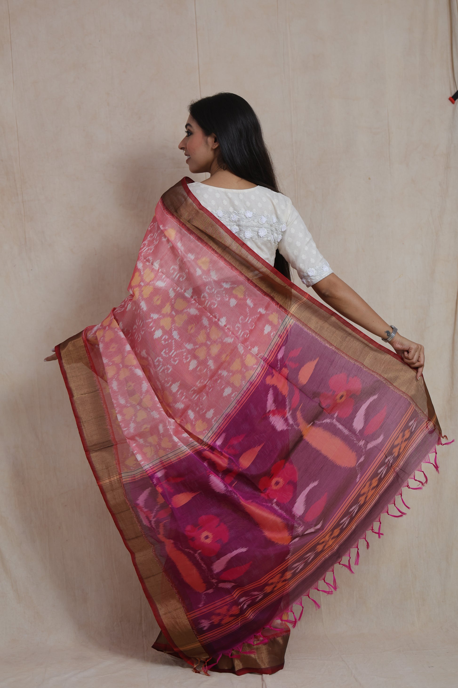 Detailed pallu view of pink Pochampally silk cotton saree with floral woven artistry and tassels