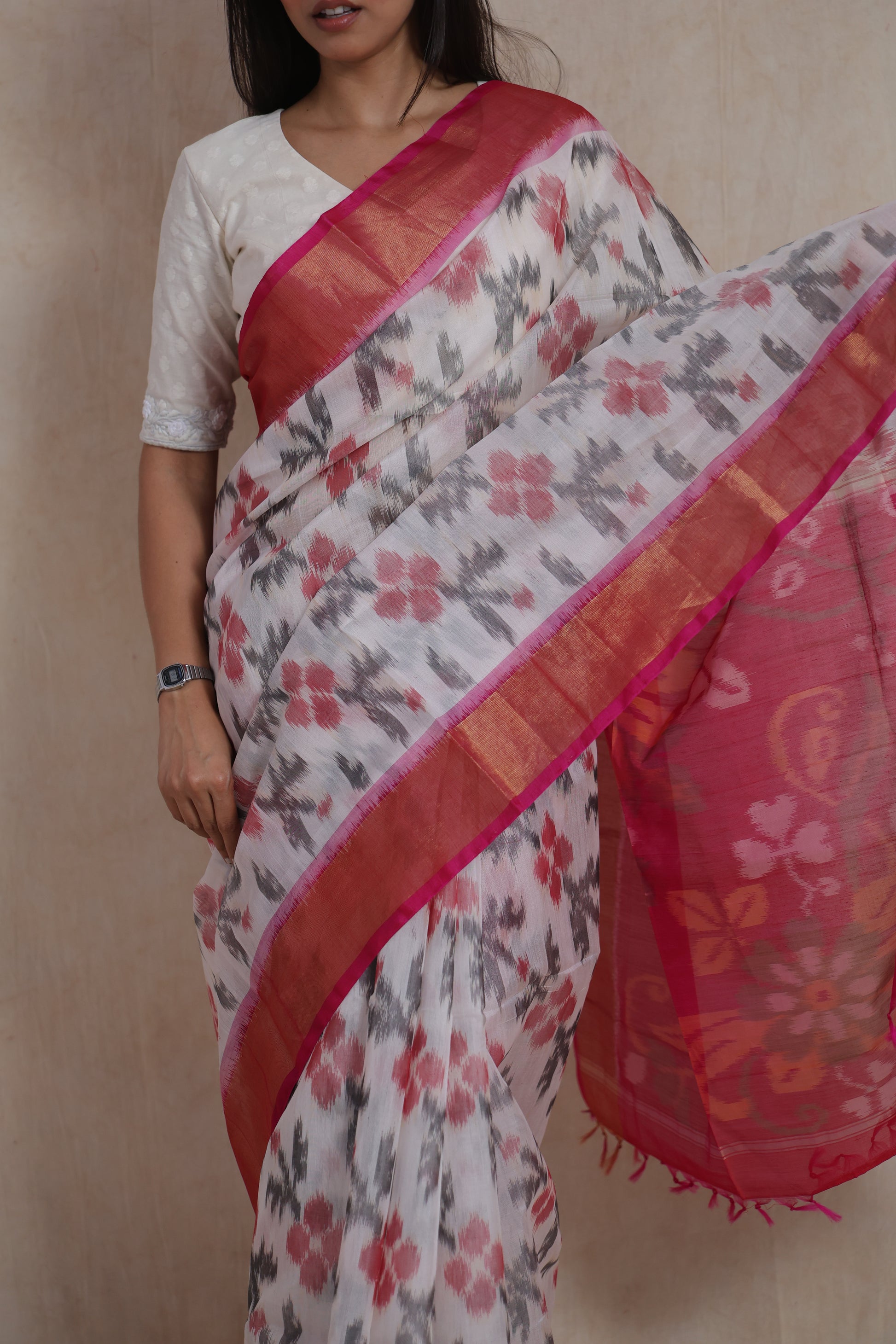 Close-up of ivory Panchampali silk cotton saree featuring pink floral Ikat motifs and contrast pink border