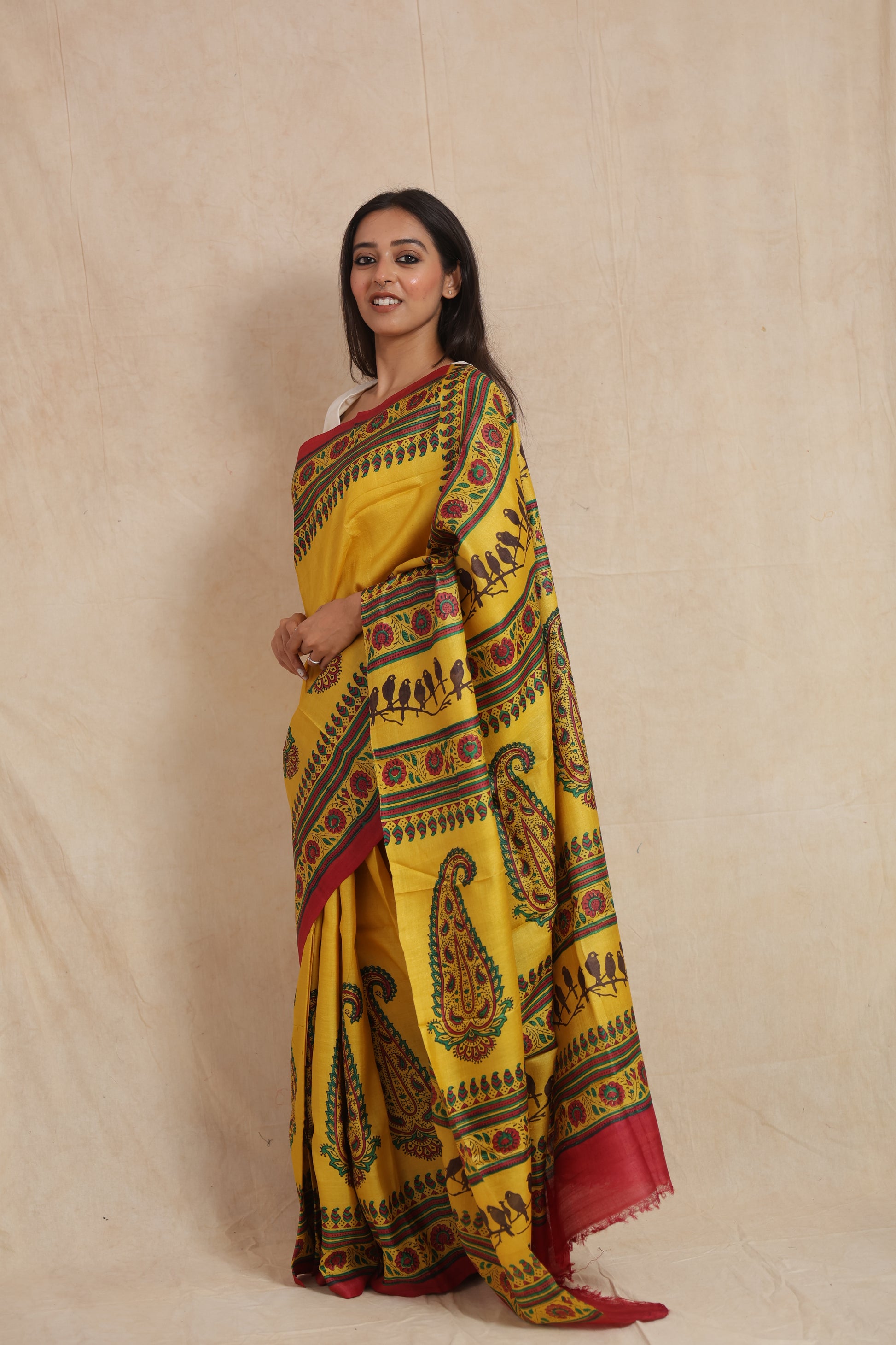 Side profile of sunshine yellow Tussar saree with traditional multicolor borders