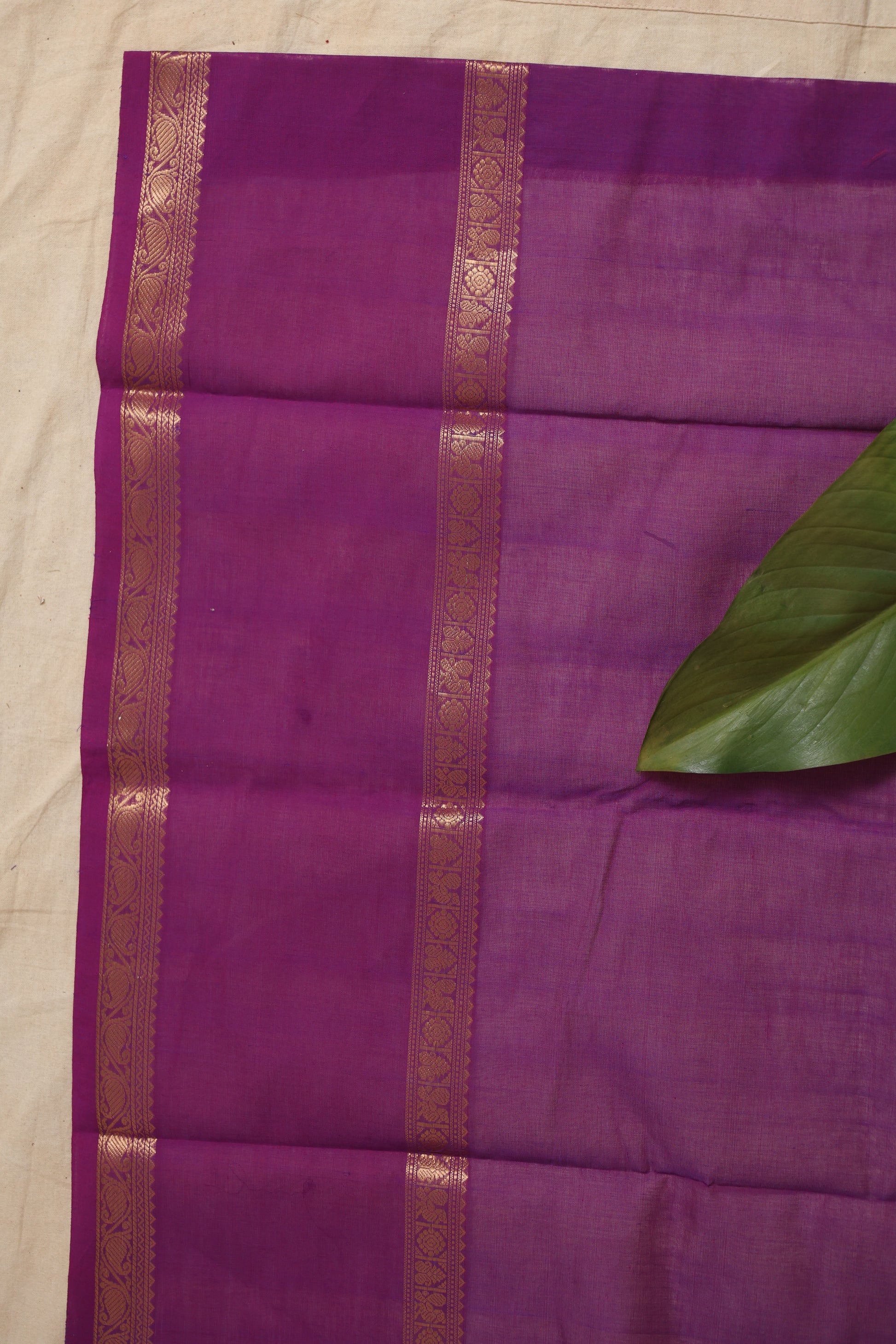 Flatlay of purple Kanchipuram cotton saree with woven border