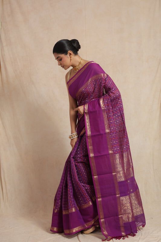 Purple Kanchipuram cotton saree with gold checks and a rich pallu, featuring a side pose showcasing traditional design and vibrant color.