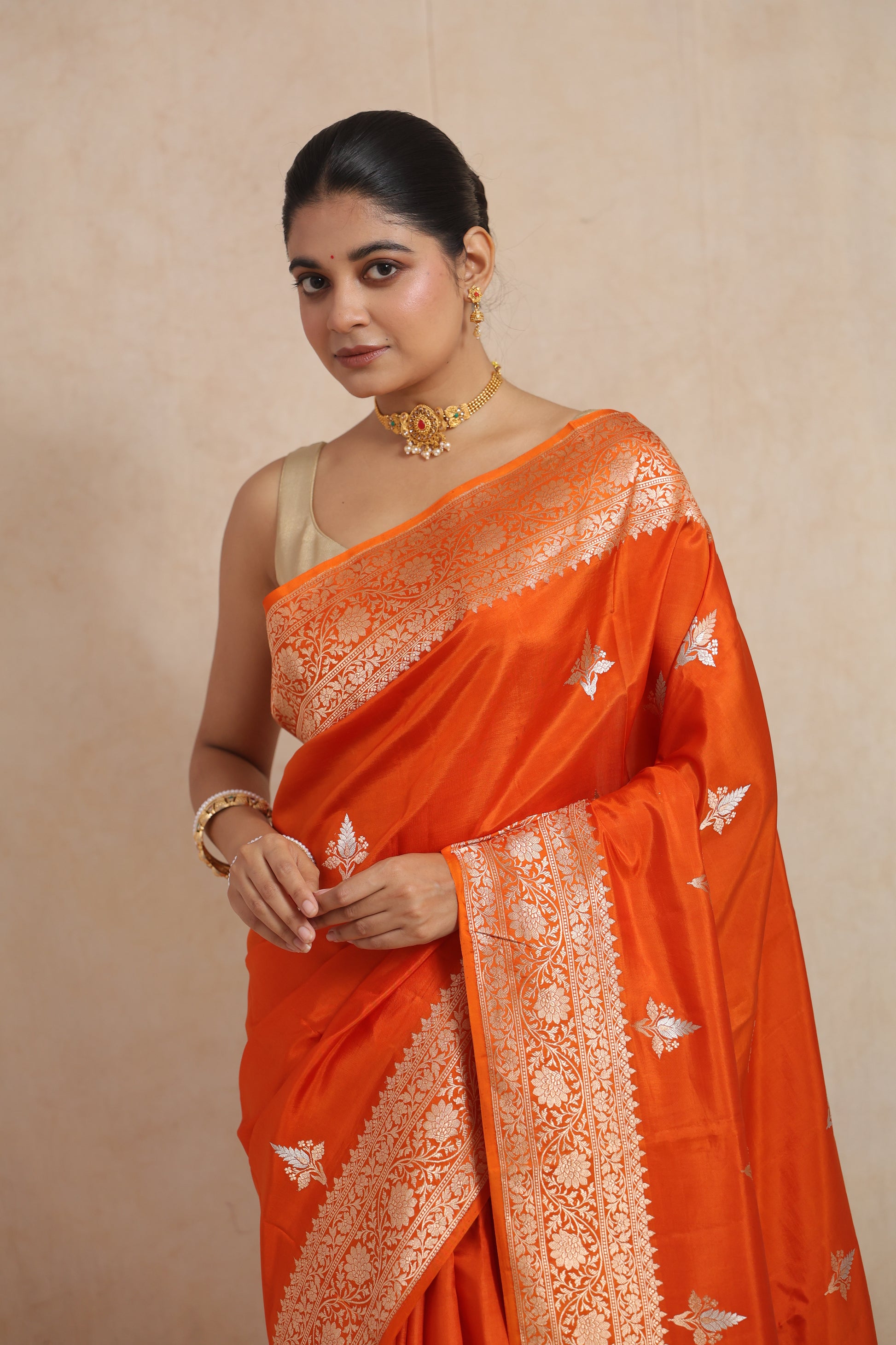 Detailed view of floral woven border and butta motifs on tangerine orange Banarasi silk saree