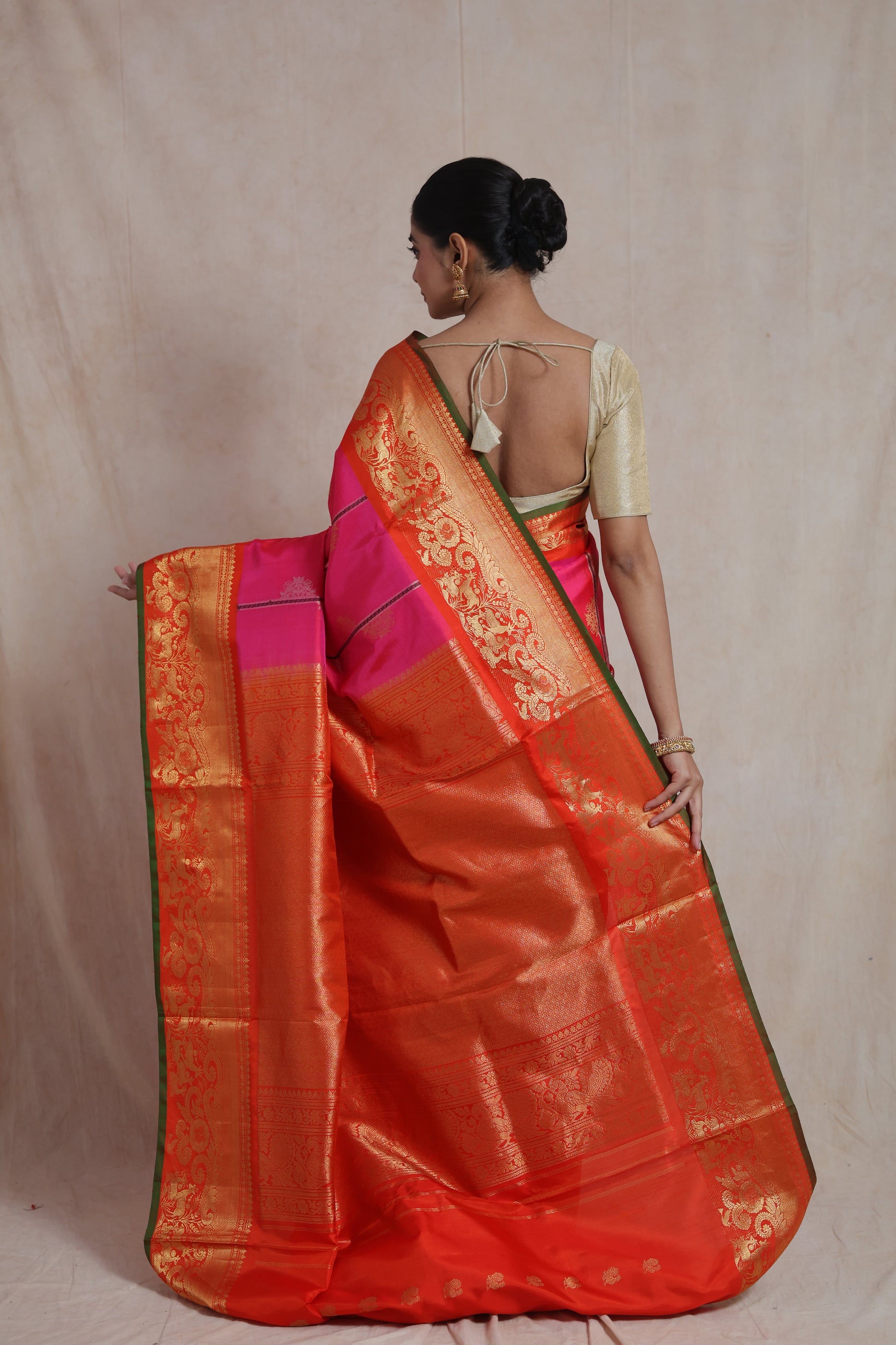 Back pallu view of rani pink Gadwal SICO saree with rich gold woven border