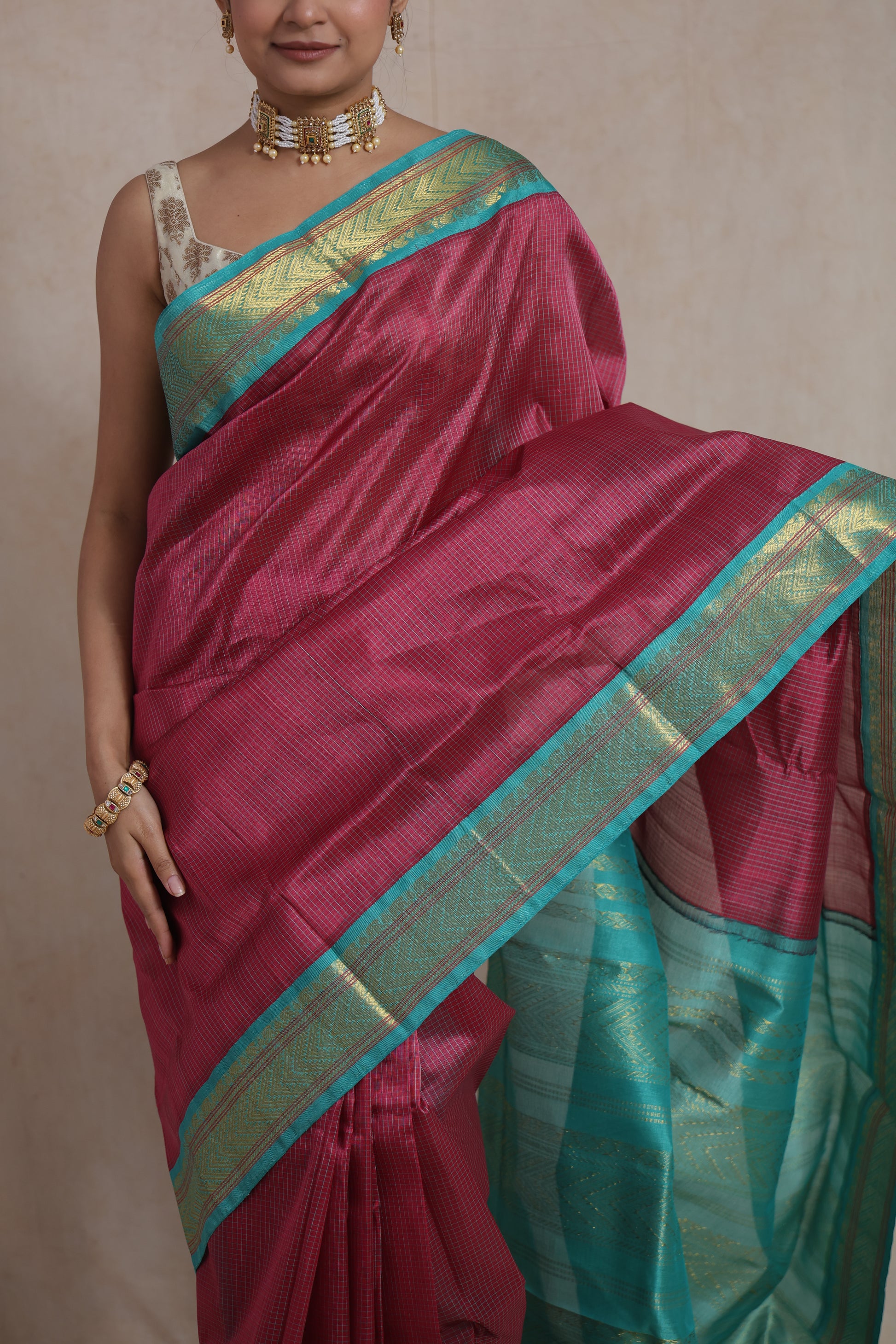 Close-up of aqua blue zari border on rani pink Kanchipuram saree